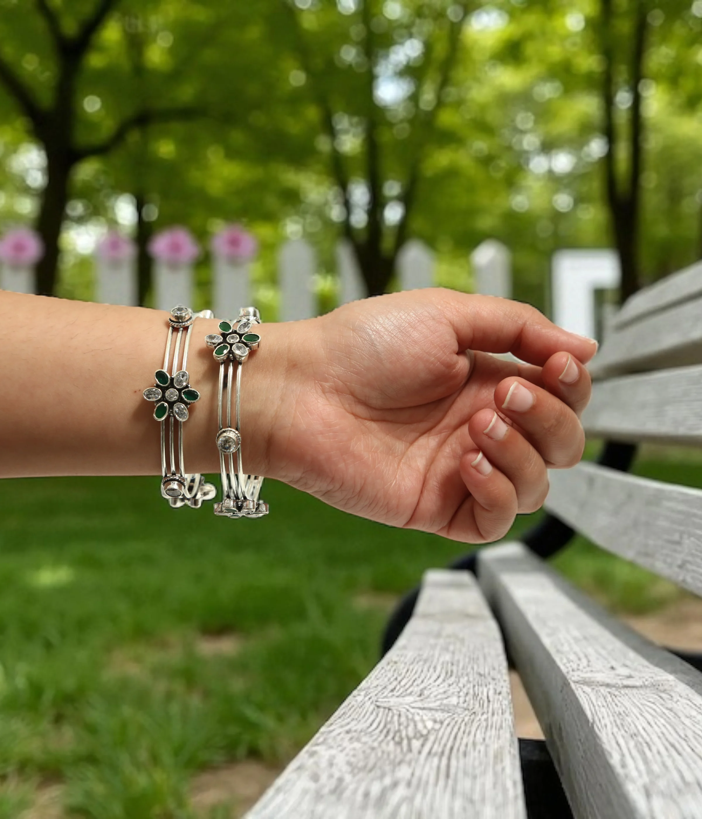 Sterling Silver Multi-Strand Bangle. Elegant design featuring a central Floral motif set with Emerald (green) and clear CZ gemstones. Stackable bracelet with an intricate, layered look.