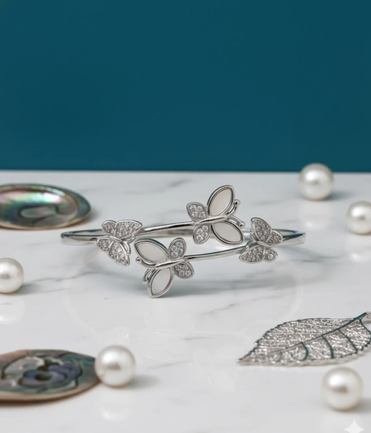 Sterling Silver Butterfly Cuff Bangle. Dainty open bypass bracelet featuring four butterfly motifs set with iridescent Mother of Pearl (MOP) and clear CZ stones. Elegant stackable jewelry.