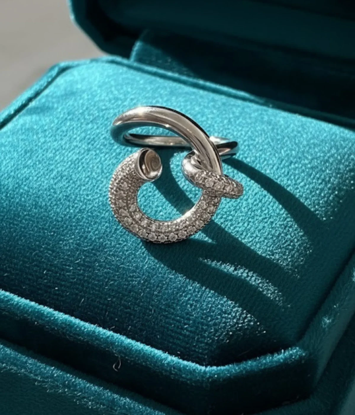 Sterling Silver Crossover Statement Ring. Modern design featuring a smooth band that crosses a sparkling pave CZ hook or dangle element. Contemporary Cocktail Ring.