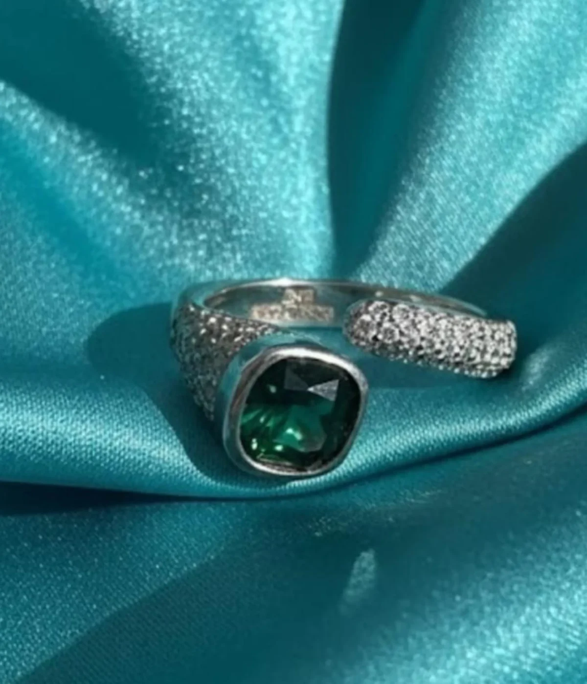 Sterling Silver Green Stone Statement Ring. Features a bold cushion-cut simulated Emerald gem and a dazzling pave CZ open bypass band. Modern Cocktail Ring.