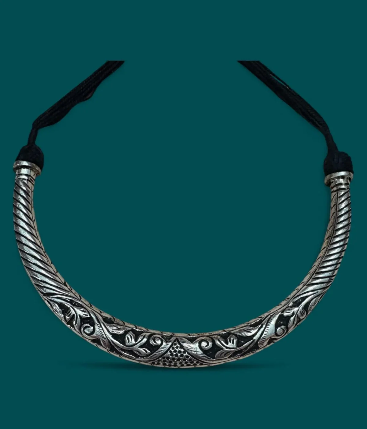 Reversible 925 Silver Hasli Necklace (Choker) with intricate oxidized ethnic carving. Handcrafted, two-in-one silver jewelry displayed on a dark wooden background.