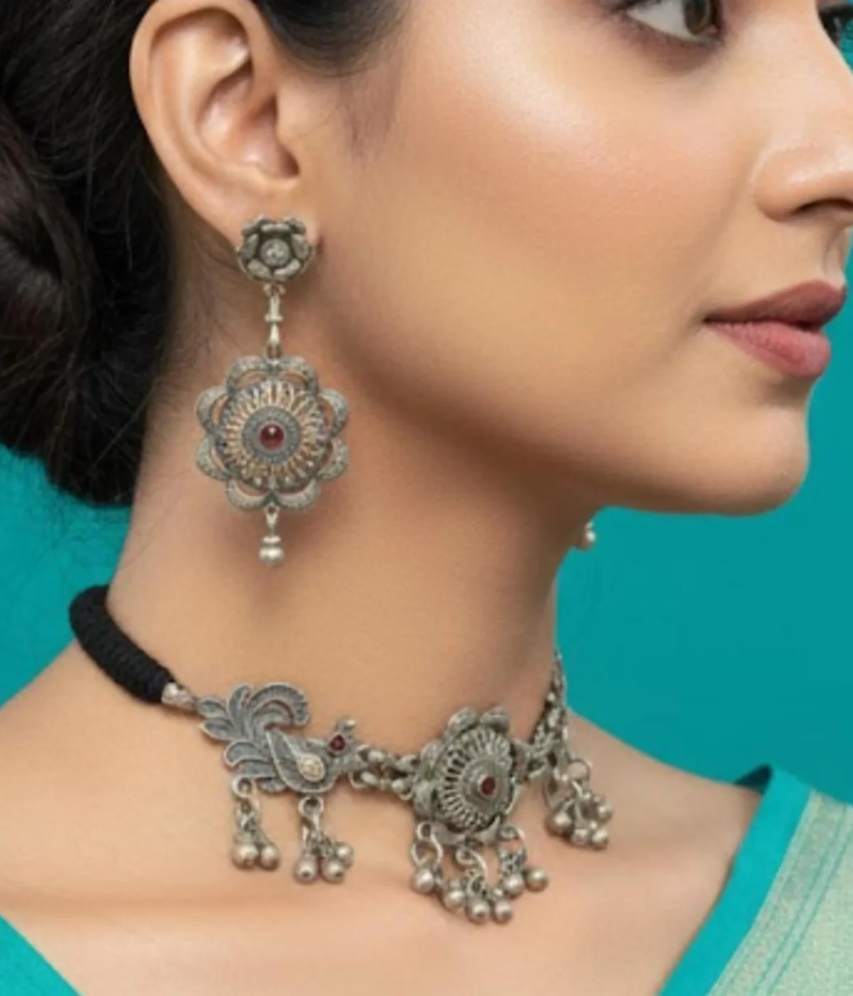 Oxidized Silver Necklace and Earring Set featuring a Floral Tribal Choker with silver bead drops and bird motifs. Antique finish jewelry on blue-green satin.