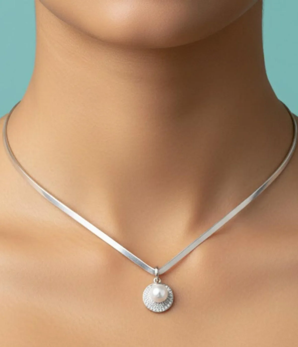Sterling Silver Collar Necklace and Pearl Stud Earring Set. Features a sleek silver band, a Zircon pave pendant, and matching pearl stud earrings displayed on a wooden riser.