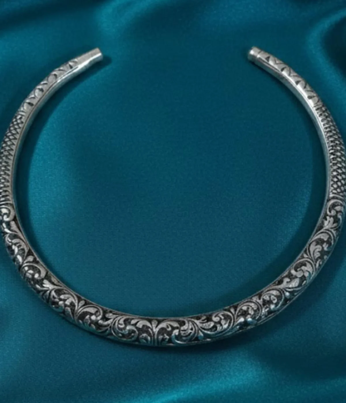 Broad Oxidized Silver Floral Choker Necklace. The rigid collar features detailed medallion engraving and a dark antique finish.