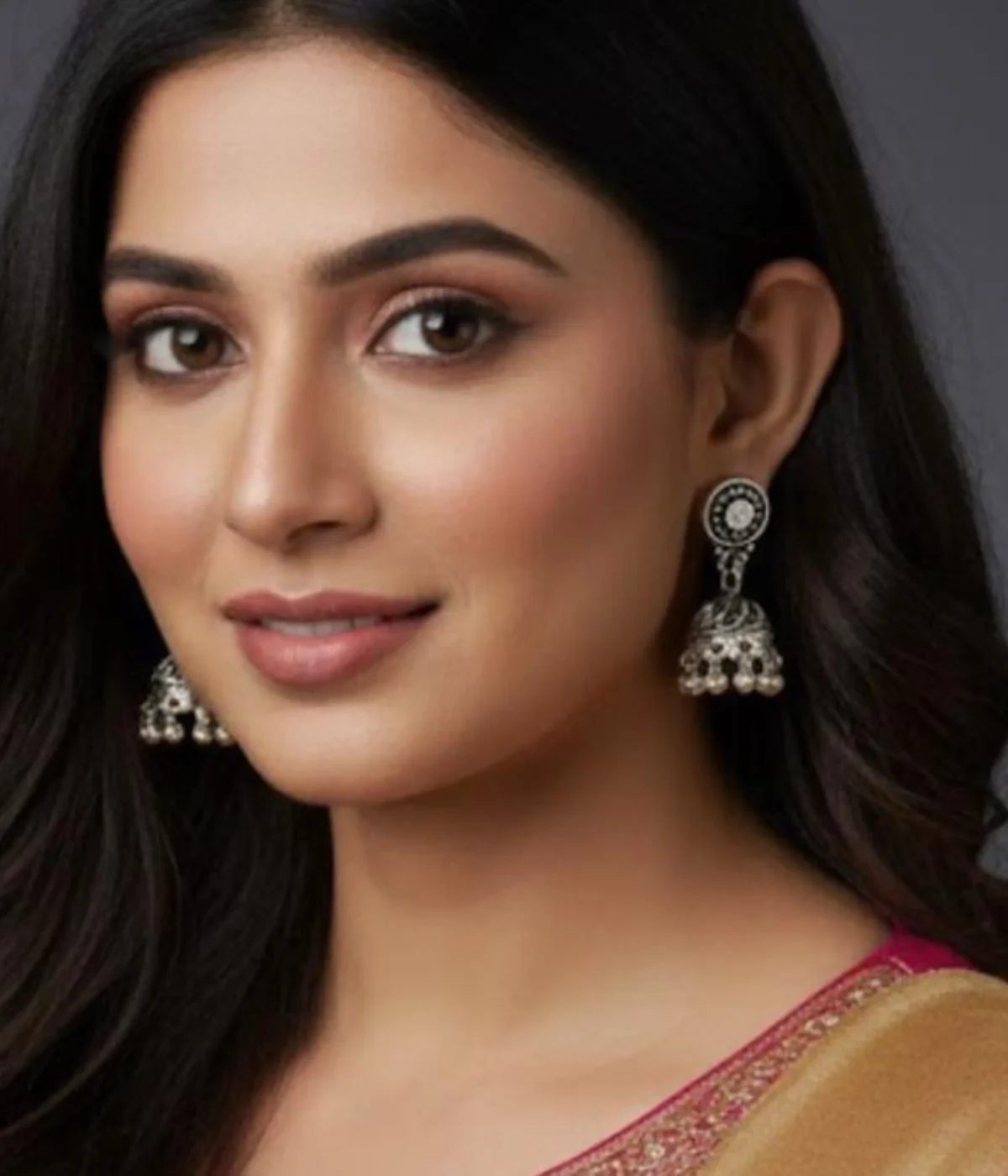 Pair of Oxidized Silver Jhumka Earrings. Traditional bell shape with crystal studs and ghungroo drops, displayed against a warm wooden background.