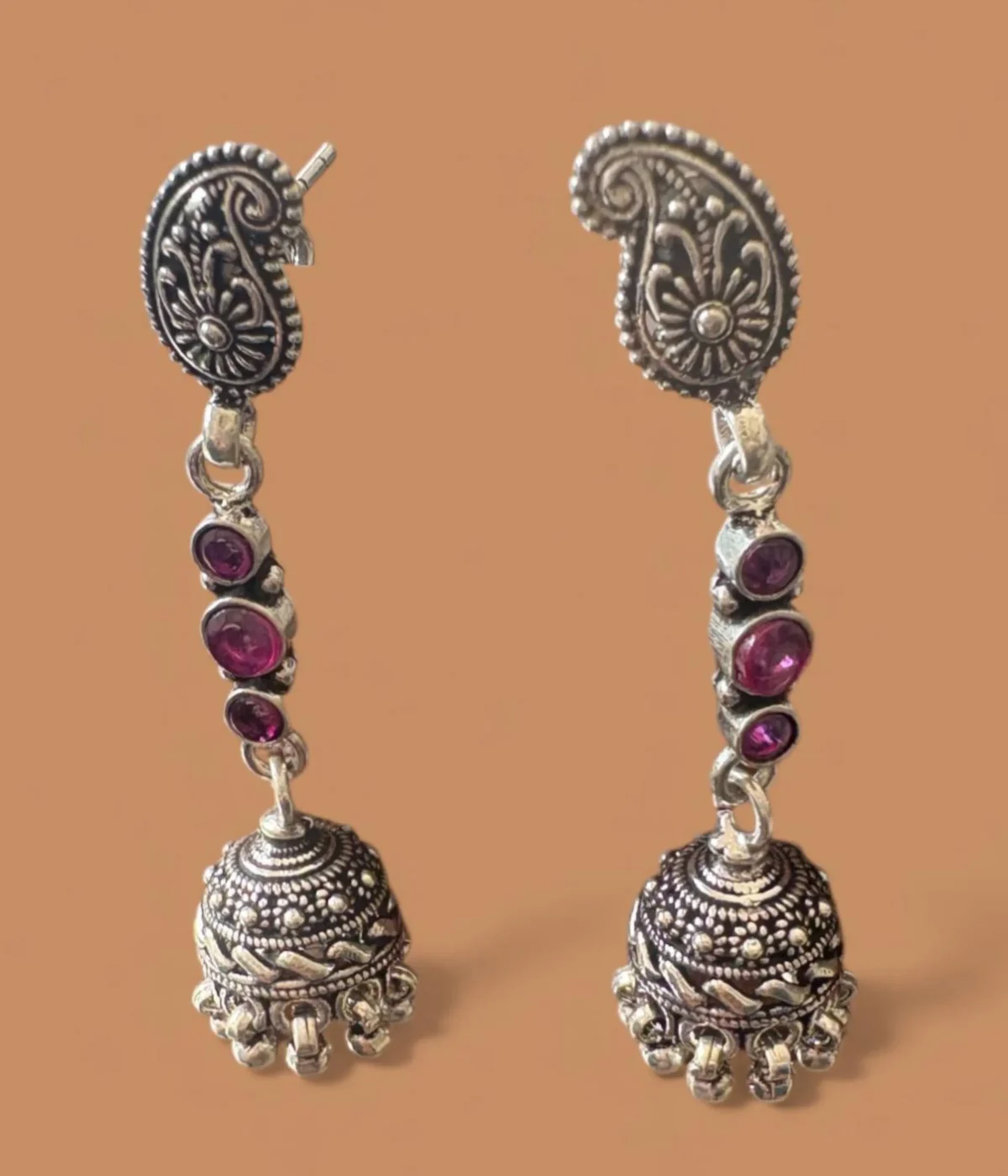 Pair of Oxidized Silver Jhumka Earrings. Long drop featuring a detailed Paisley Stud, a chain of Pink Stones, and a traditional Jhumka bell bottom.