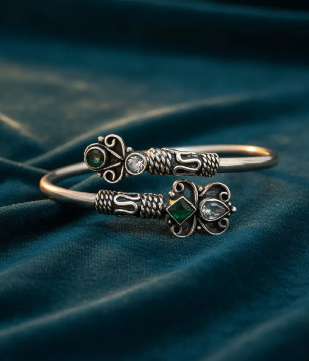 Ethnic oxidized silver open cuff bangle with intricate tribal detailing, featuring green stone and clear crystal accents in a Boho butterfly design.