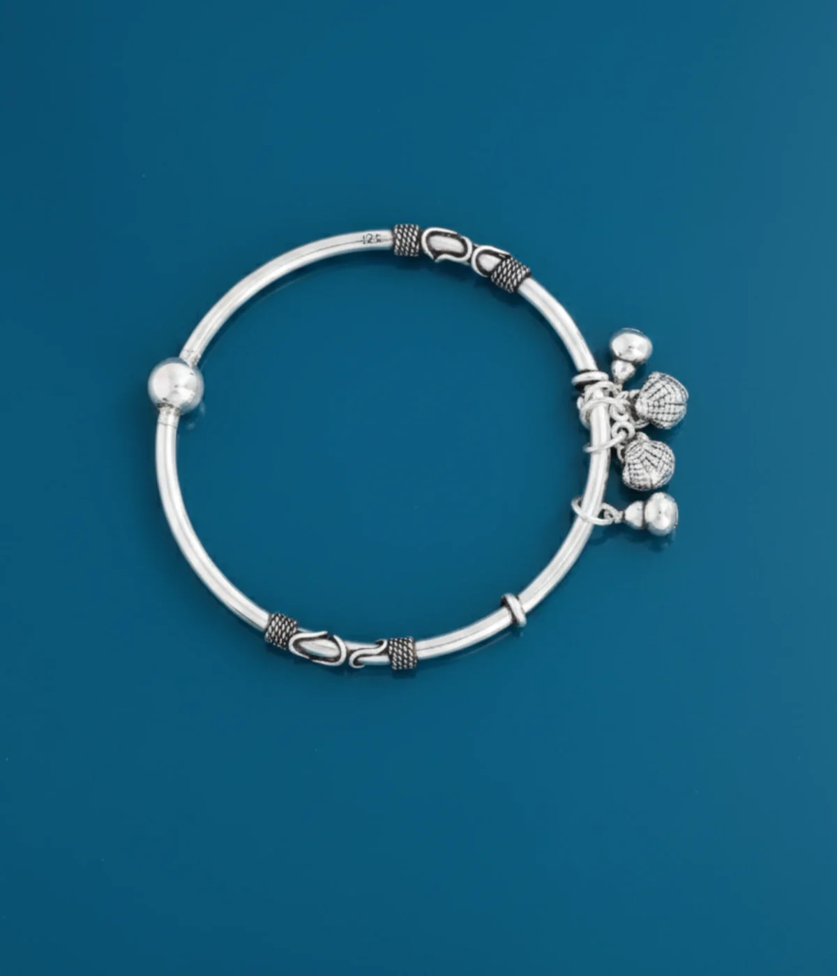 925 Sterling Silver Ghungroo Bangle | Oxidized Tribal Charm Bracelet with jingle bells on a dark blue background.