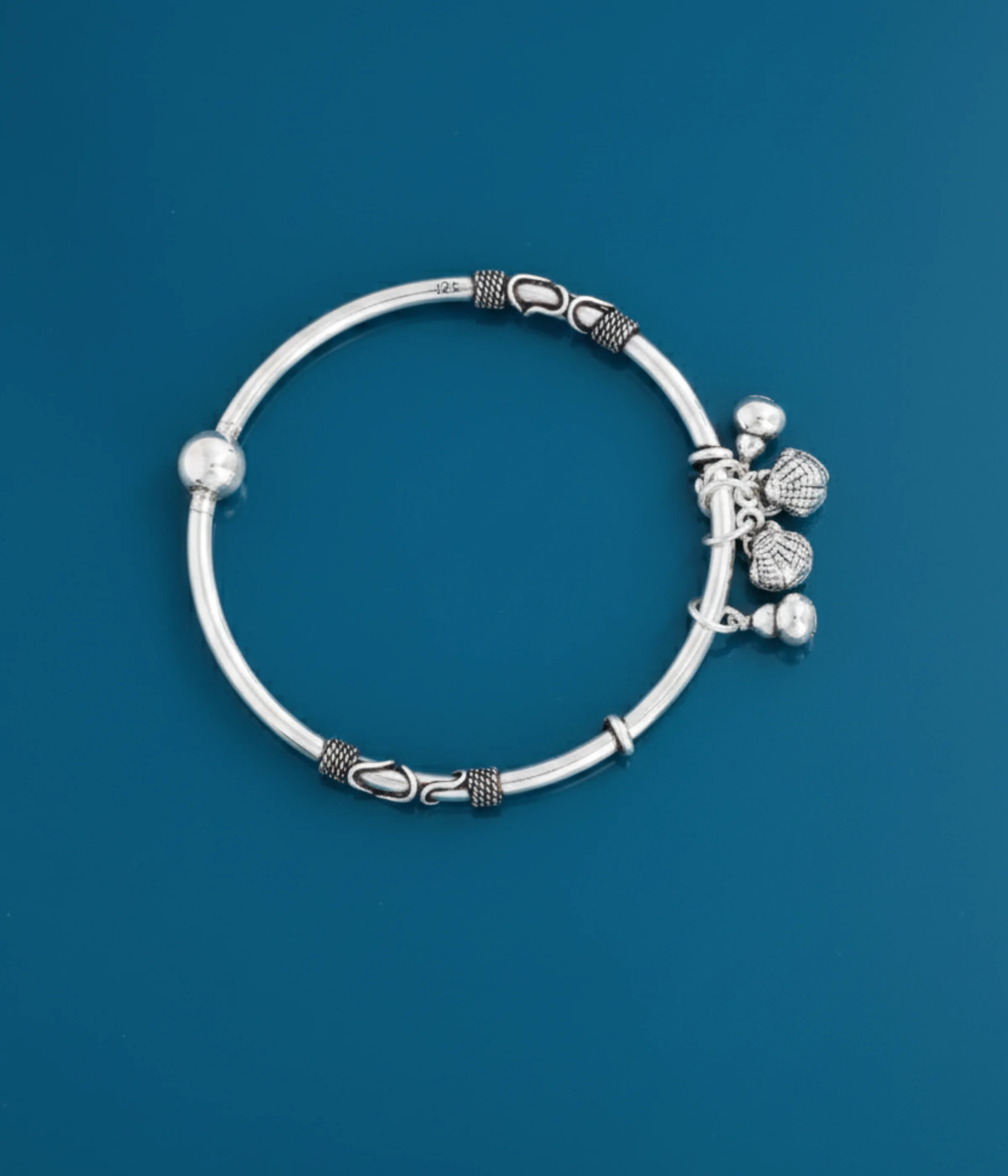 925 Sterling Silver Ghungroo Bangle | Oxidized Tribal Charm Bracelet with jingle bells on a dark blue background.