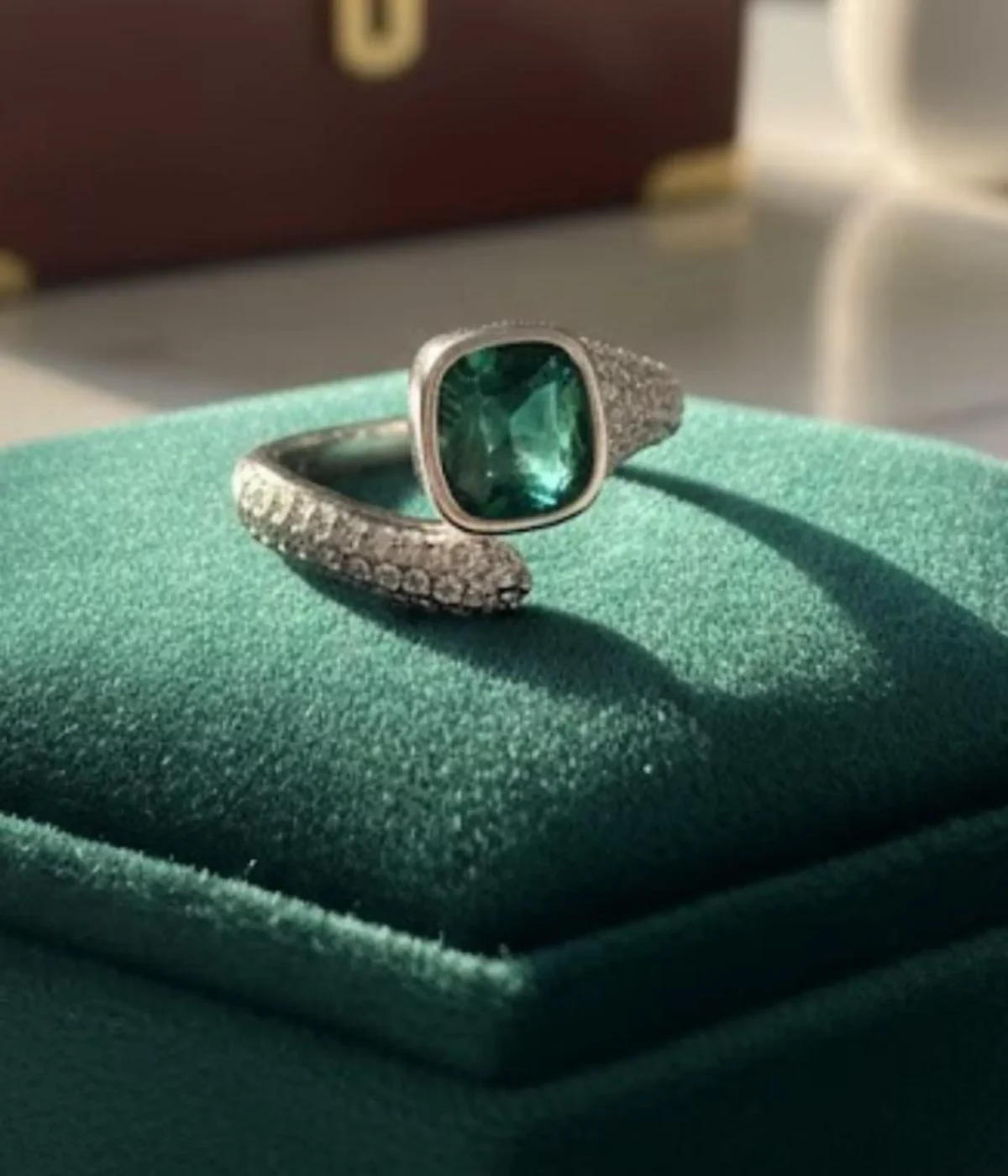 Sterling Silver Green Stone Statement Ring. Features a bold cushion-cut simulated Emerald gem and a dazzling pave CZ open bypass band. Modern Cocktail Ring.