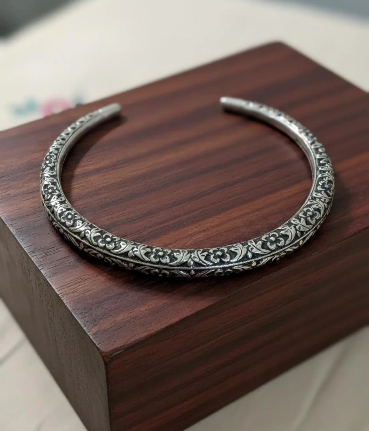 Broad Oxidized Silver Floral Choker Necklace. The rigid collar features detailed medallion engraving and a dark antique finish.