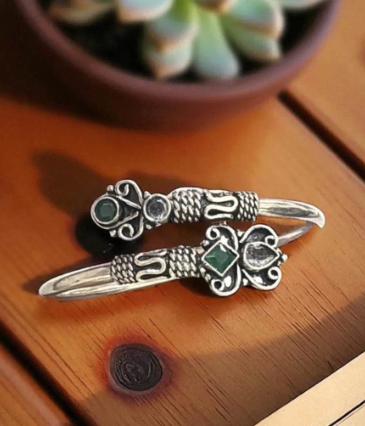 Ethnic oxidized silver open cuff bangle with intricate tribal detailing, featuring green stone and clear crystal accents in a Boho butterfly design.