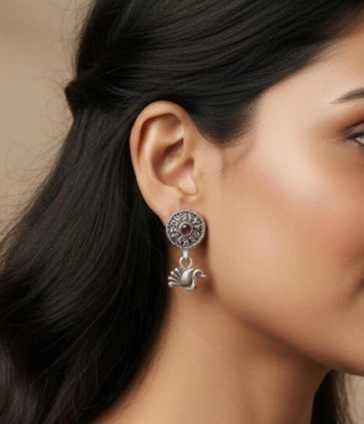Pair of Oxidized Silver Peacock Drop Earrings. Features a central ruby stone stud and a detailed peacock dangle, displayed on red velvet inside a wooden jewelry box.