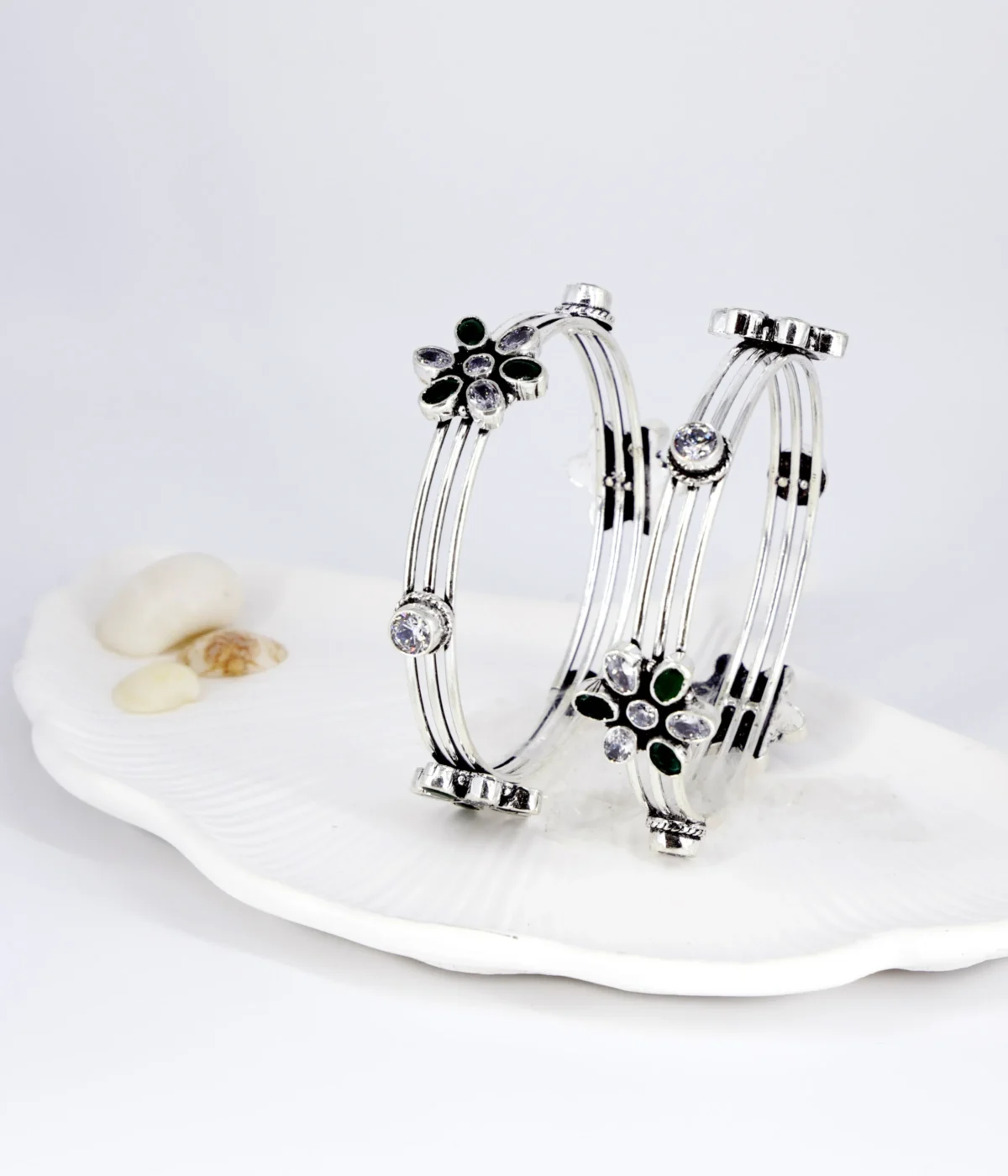 Sterling Silver Multi-Strand Bangle. Elegant design featuring a central Floral motif set with Emerald (green) and clear CZ gemstones. Stackable bracelet with an intricate, layered look.