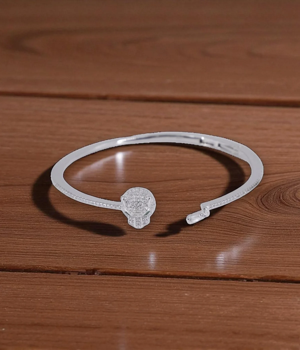 Neersterling Silver-tone open cuff bangle with a pave CZ circle centerpiece and rhinestone-lined edges.