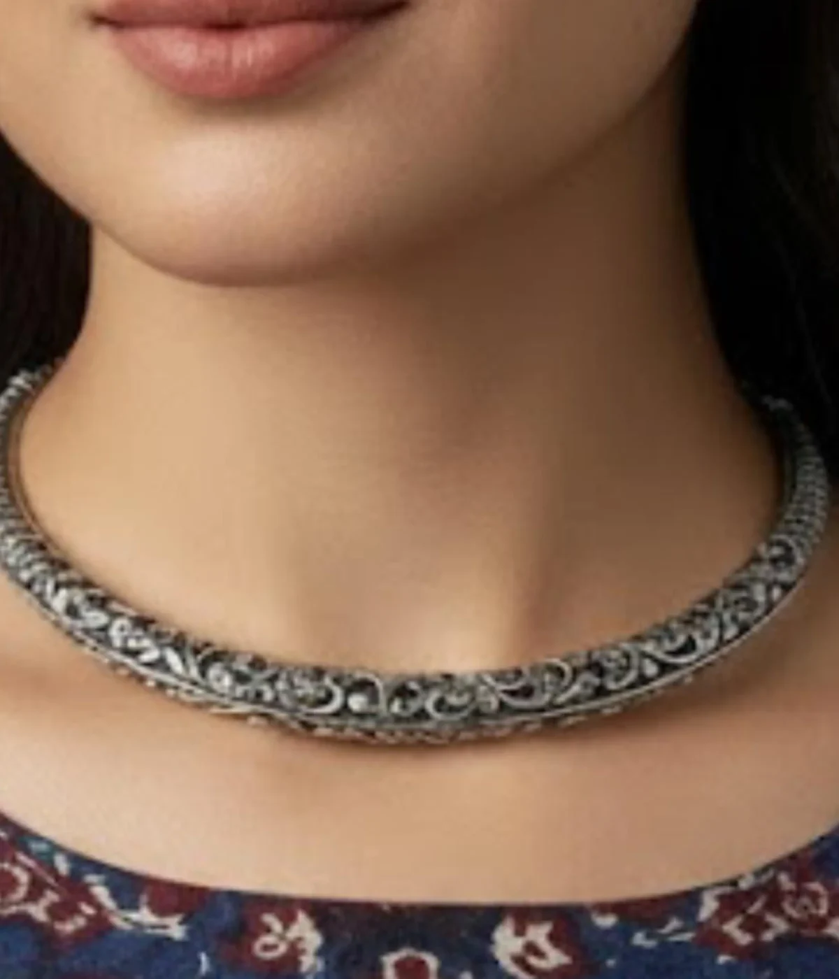 Broad Oxidized Silver Floral Choker Necklace. The rigid collar features detailed medallion engraving and a dark antique finish.