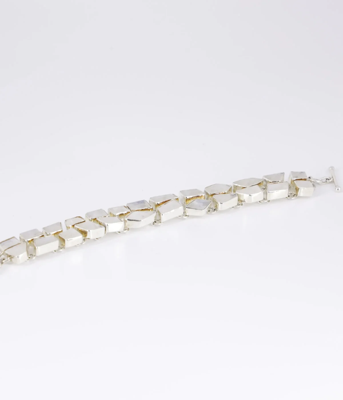 NeerSterling Silver Moonstone link bracelet featuring two rows of unevenly cut stones on a white background.