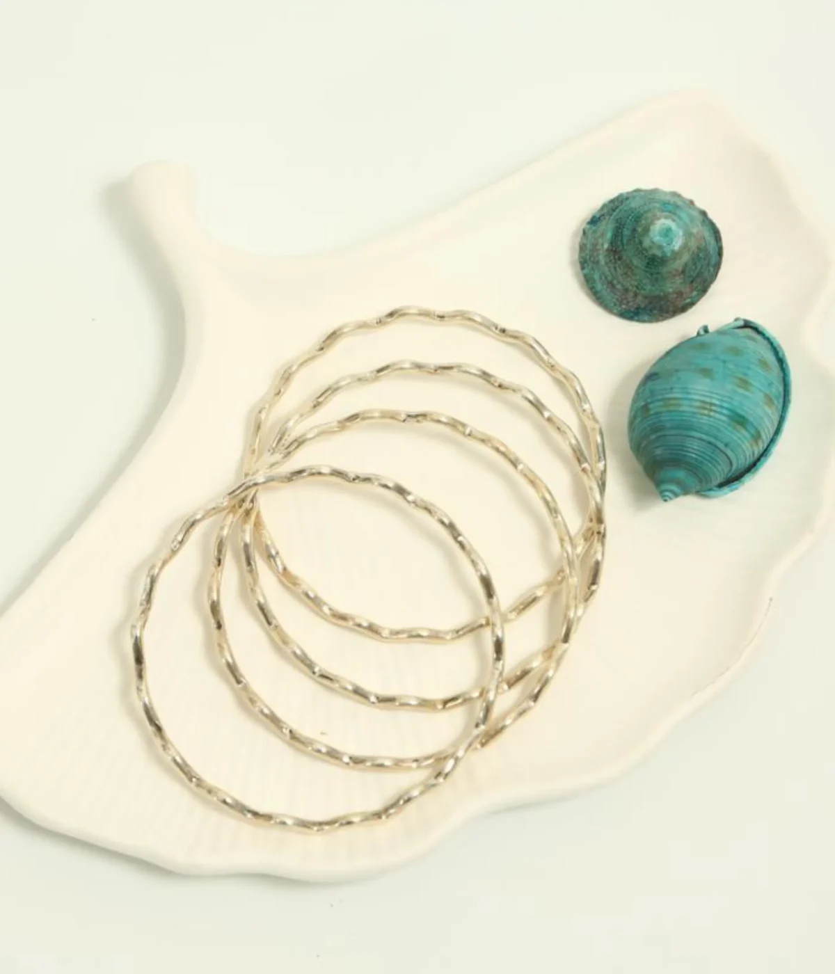 Set of 4 Sterling Silver Wave Stacking Bangles featuring a minimalist ripple texture. Dainty 925 silver layering jewelry and a unique everyday gift for women.