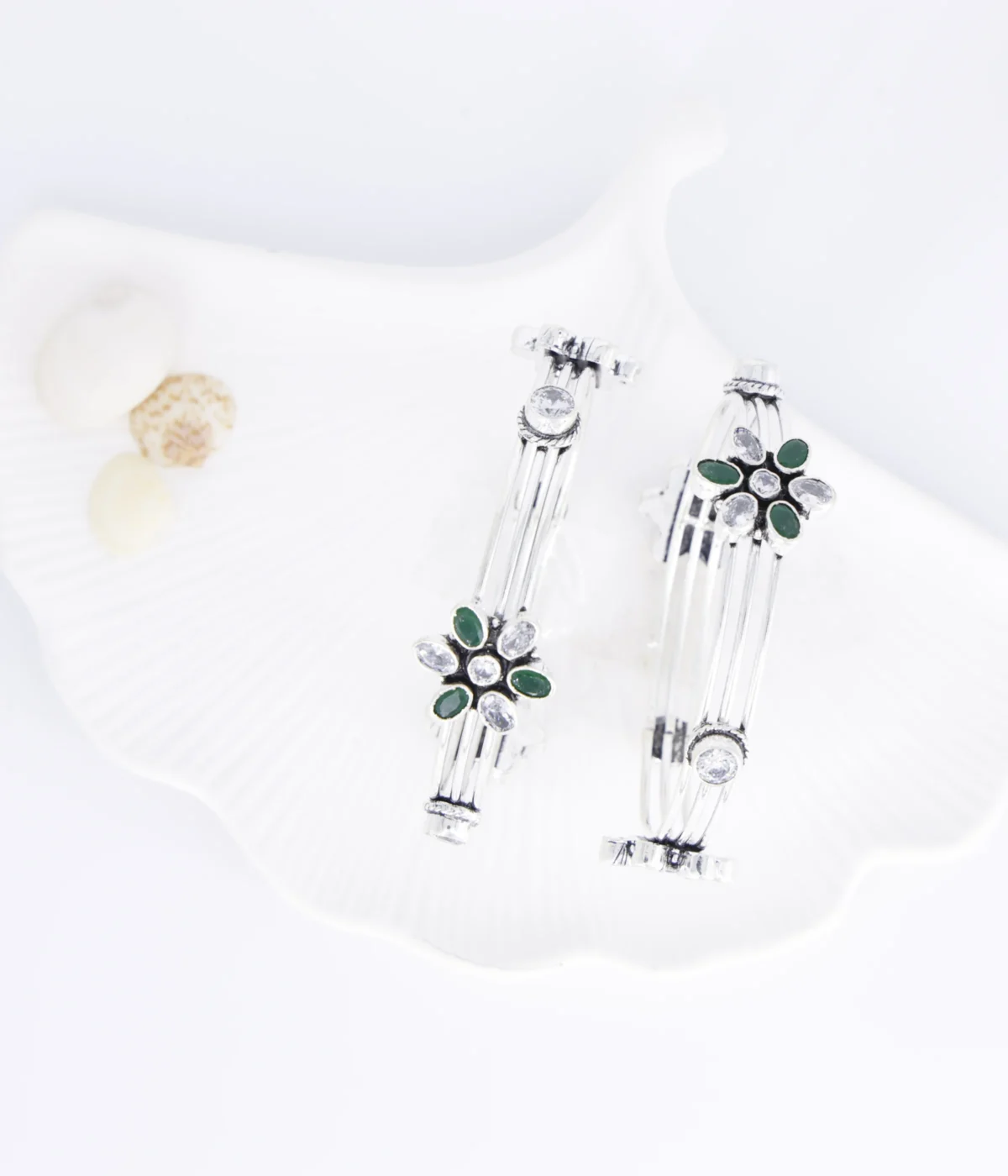 Sterling Silver Multi-Strand Bangle. Elegant design featuring a central Floral motif set with Emerald (green) and clear CZ gemstones. Stackable bracelet with an intricate, layered look.