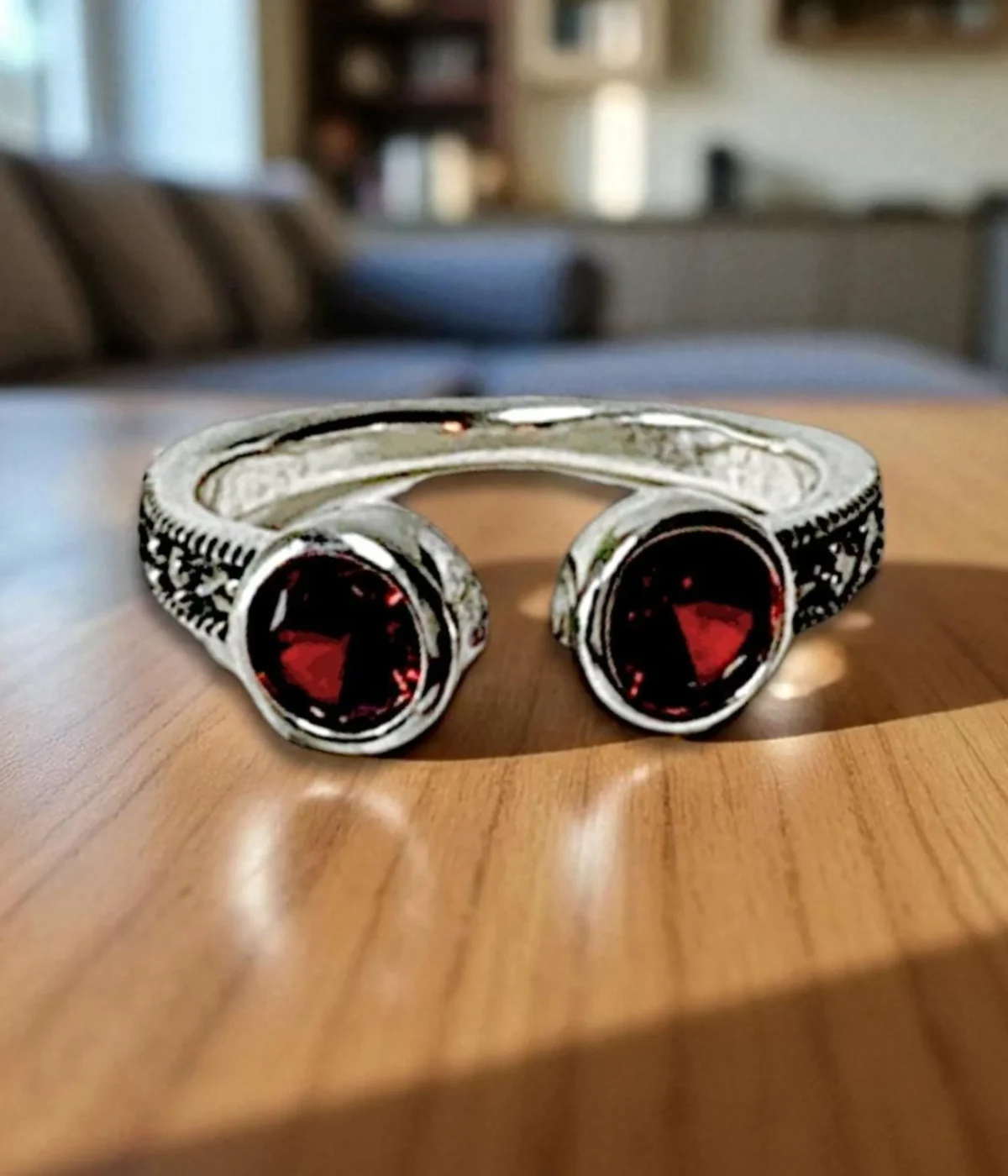 Sterling Silver Open Cuff Ring. Features a bypass design with two Bezel-set Red Garnet Style round stones at the ends. Adjustable and has a textured band.