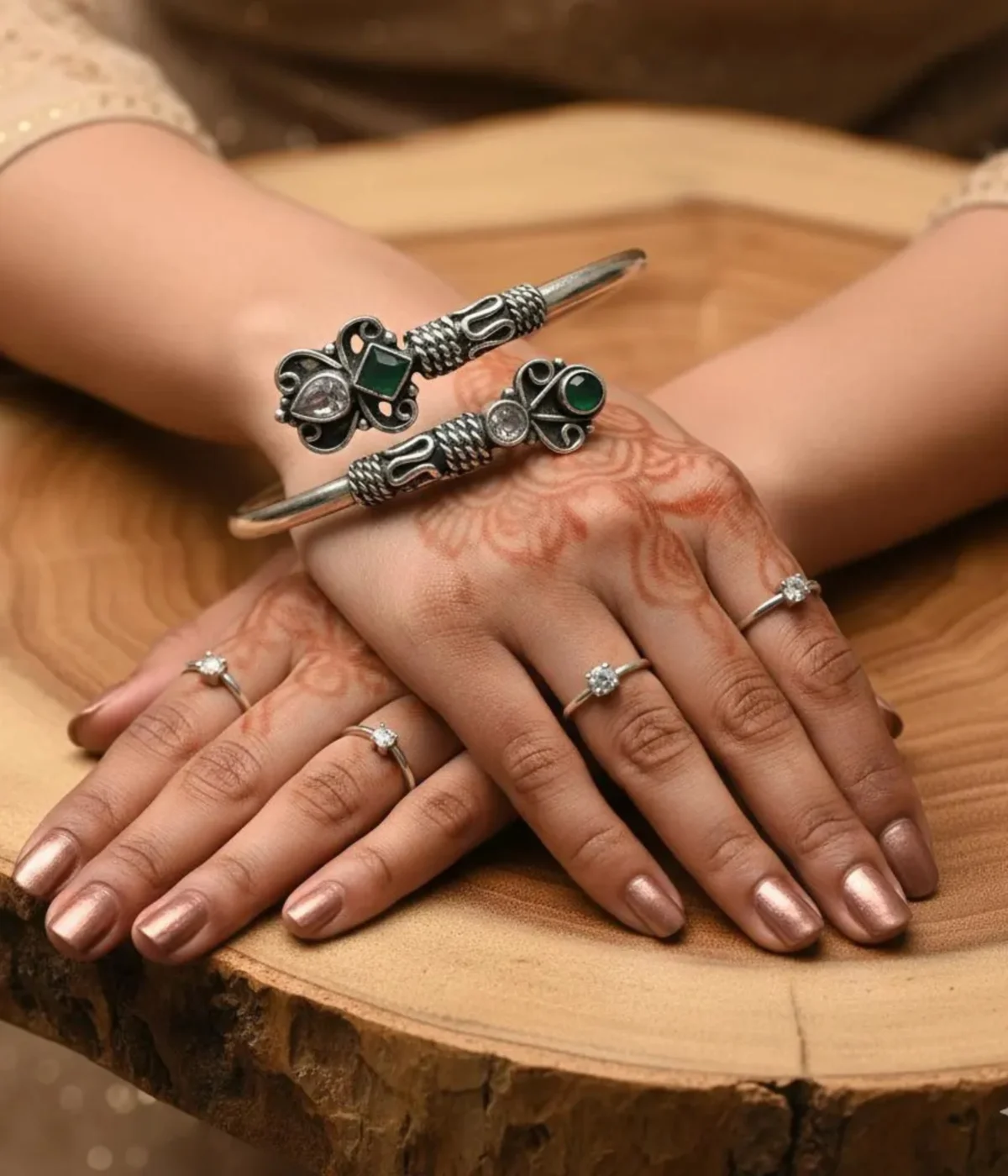 Ethnic oxidized silver open cuff bangle with intricate tribal detailing, featuring green stone and clear crystal accents in a Boho butterfly design.