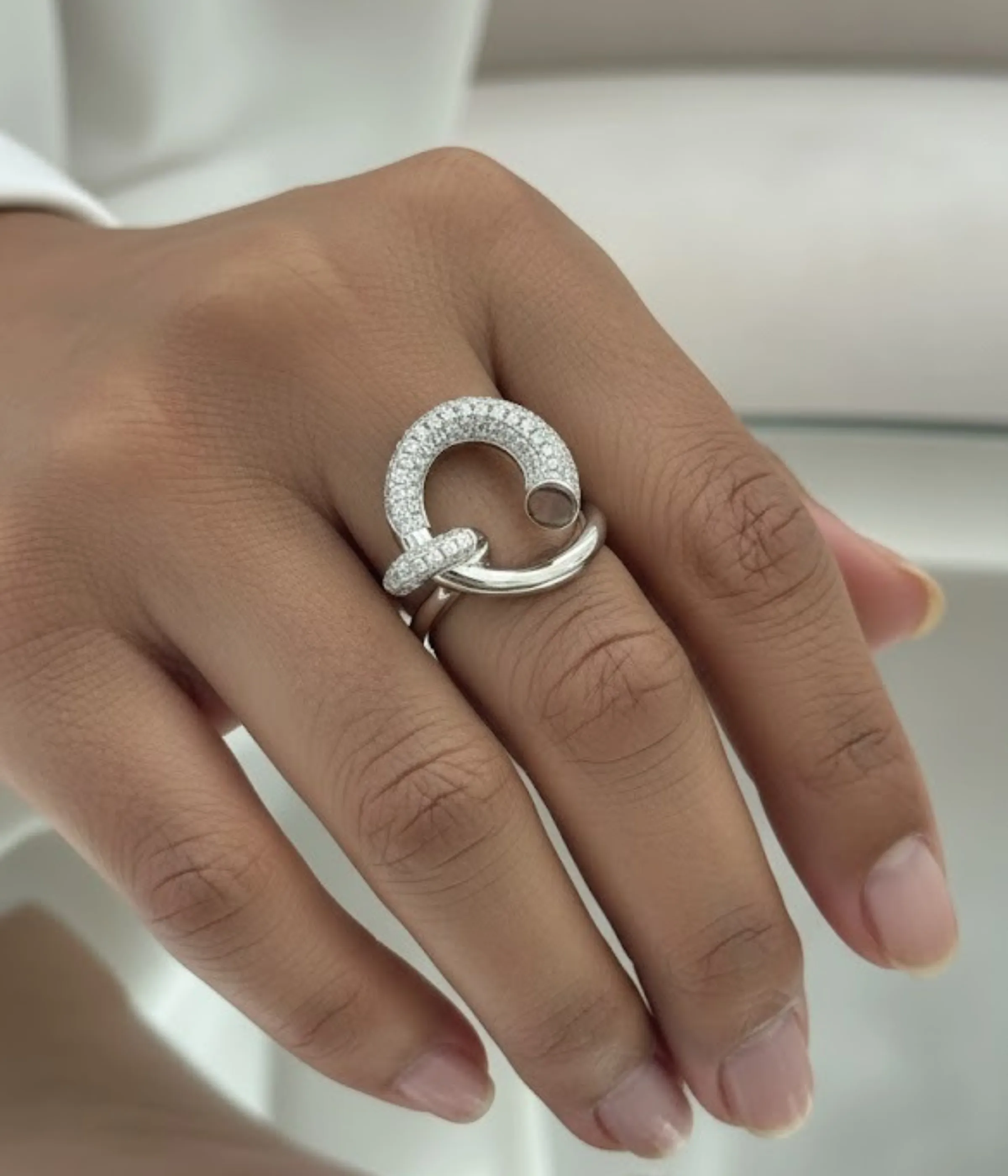 Sterling Silver Crossover Statement Ring. Modern design featuring a smooth band that crosses a sparkling pave CZ hook or dangle element. Contemporary Cocktail Ring.