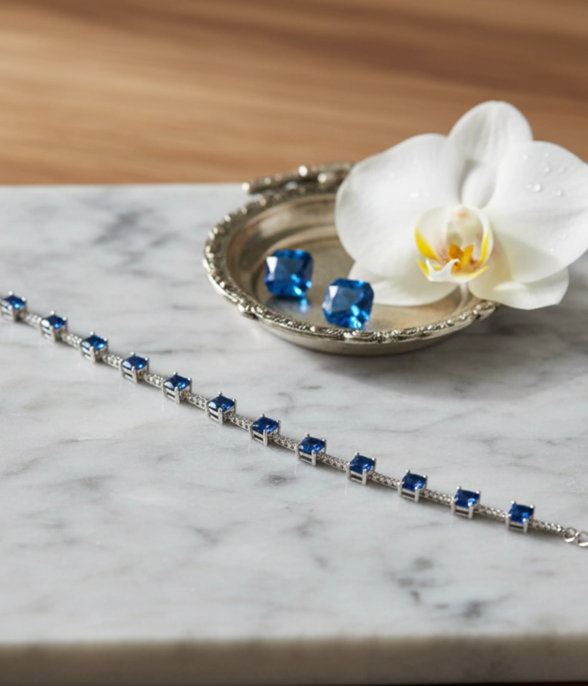 NeerSterling Silver Blue Gemstone Line Bracelet. Dainty 925 silver chain featuring a continuous line of round blue/sapphire-colored solitaire stations. Minimalist stacking jewelry.