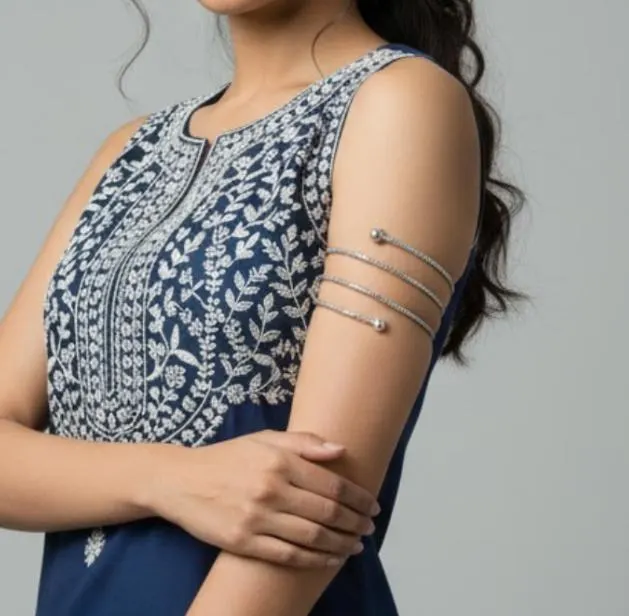 NeerSterling Silver Coiled Spiral Bracelet. Multi-turn textured silver wire wraps around itself with ball finials. Bohemian adjustable arm cuff on a blue satin background.