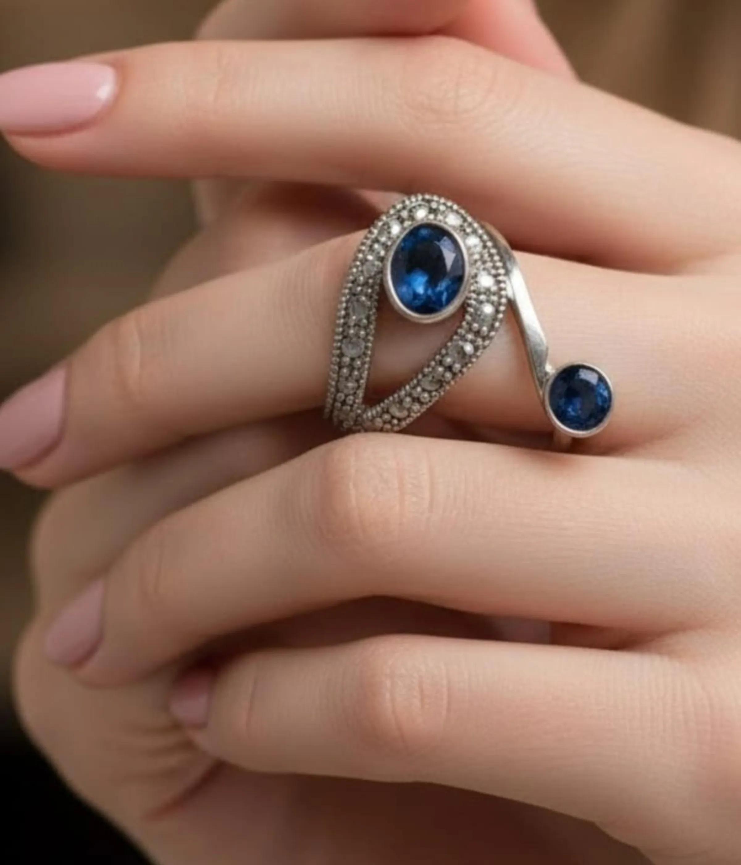 Vintage Style Blue Sapphire Bypass Ring. Sterling Silver two-stone design featuring a large oval and small round Sapphire Blue stone, accented with milgrain and clear pave details. Art Deco Statement Jewelry.