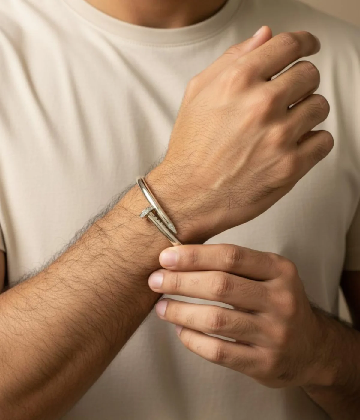 Men's Sterling Silver Nail Kada (cuff bracelet). The sleek, modern design features pave-set Cubic Zirconia stones detailing the nail head and tip. Photographed on a luxurious teal satin surface.