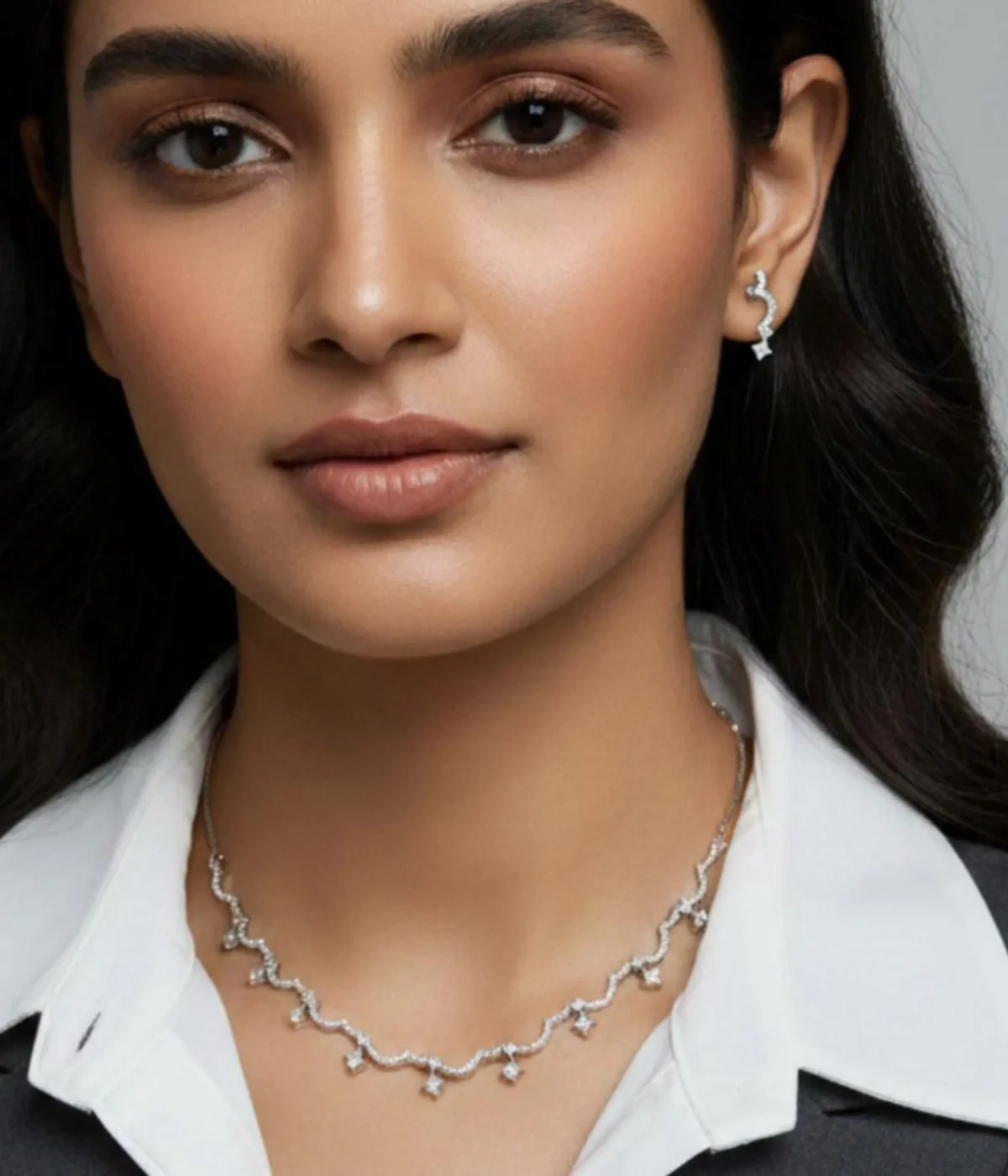 Elegant Zircon Wave Necklace and Earring Set. The necklace features a curved, sparkling diamond-style design, paired with climber stud earrings.