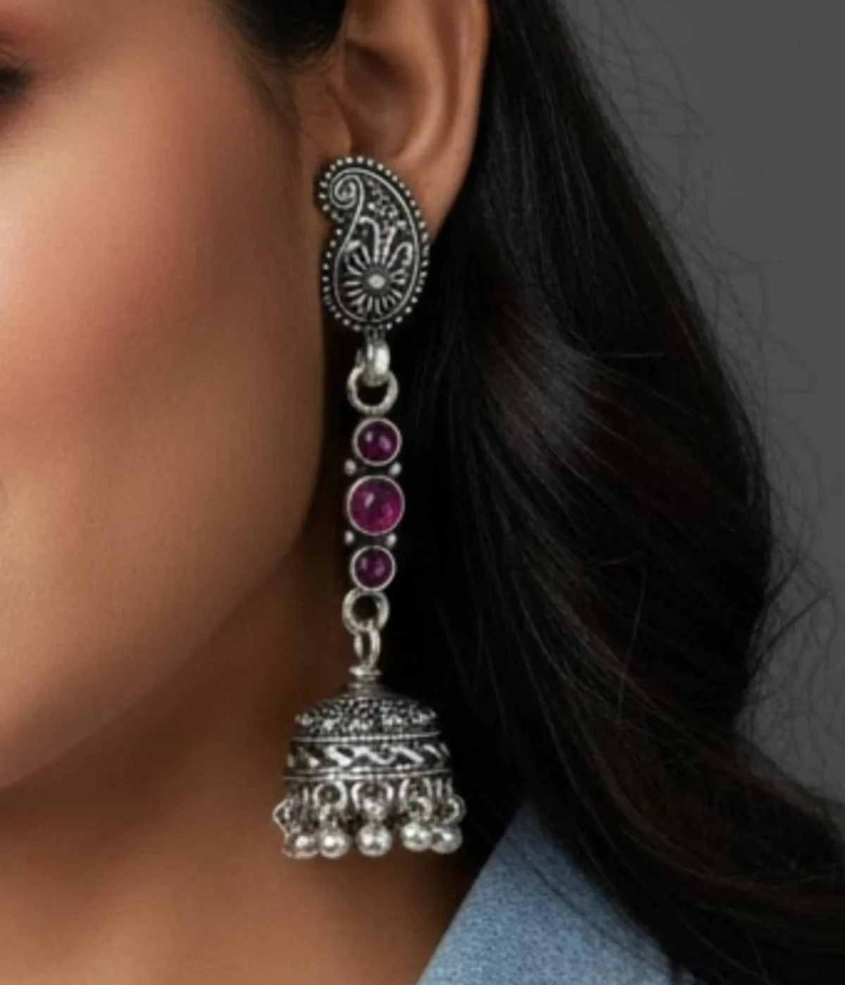 Pair of Oxidized Silver Jhumka Earrings. Long drop featuring a detailed Paisley Stud, a chain of Pink Stones, and a traditional Jhumka bell bottom.
