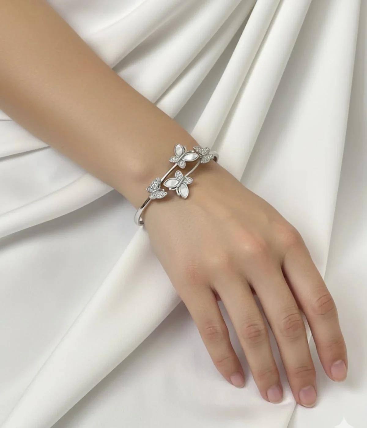 Sterling Silver Butterfly Cuff Bangle. Dainty open bypass bracelet featuring four butterfly motifs set with iridescent Mother of Pearl (MOP) and clear CZ stones. Elegant stackable jewelry.