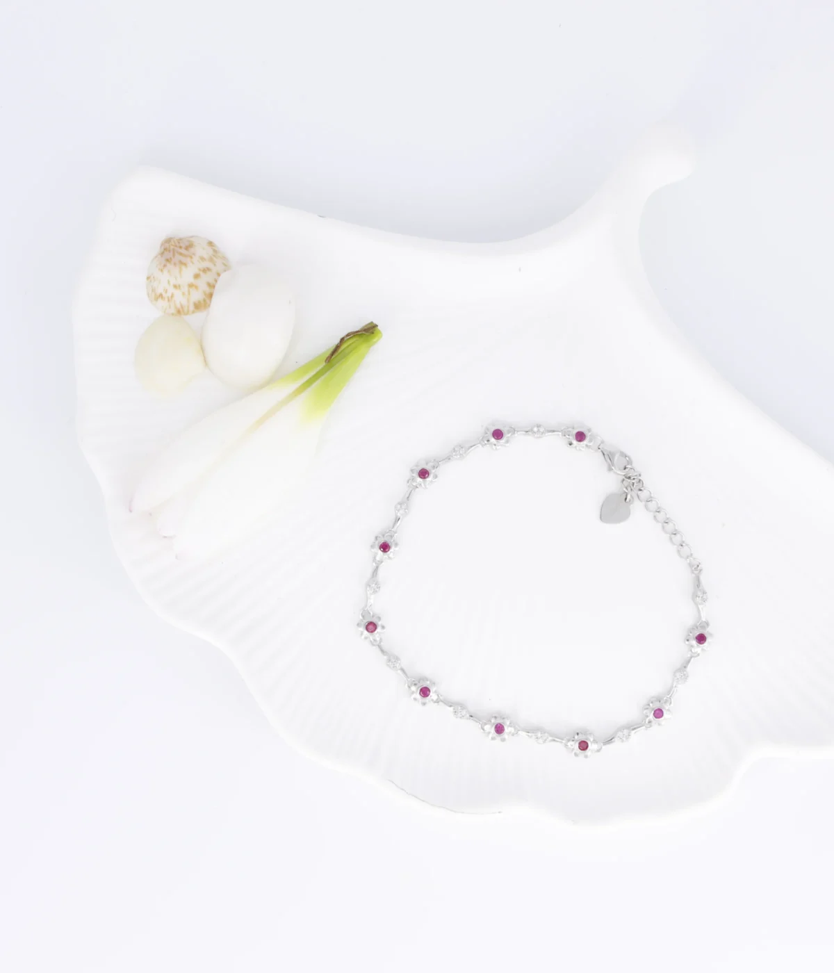 NeerSterling Silver Dainty Pink Gemstone Line Bracelet. Features a continuous line of tiny flower motifs with central pink stones (CZ/Ruby color). Minimalist 925 silver jewelry.
