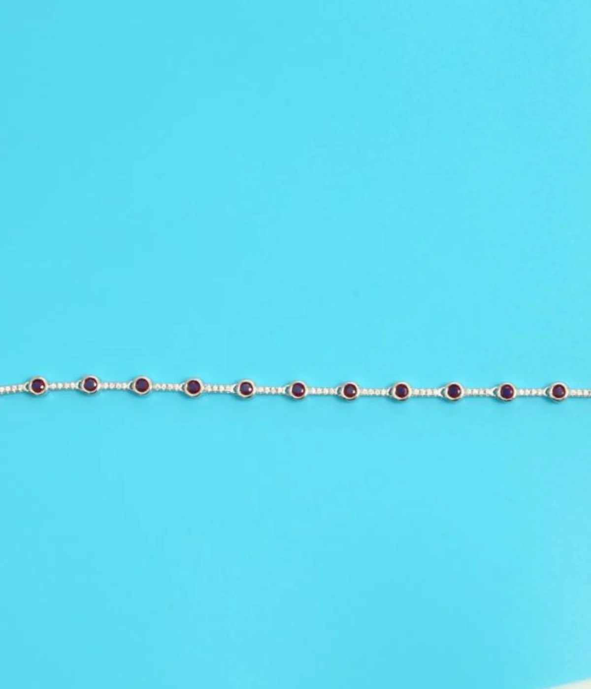 Sterling Silver Pink Gemstone Line Bracelet with round solitaire stations. Dainty 925 silver chain featuring evenly spaced pink/ruby-colored stones. Minimalist stacking bracelet.