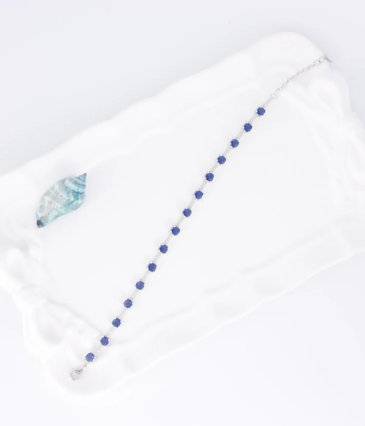 NeerSterling Silver Blue Gemstone Line Bracelet. Dainty 925 silver chain featuring a continuous line of round blue/sapphire-colored solitaire stations. Minimalist stacking jewelry.