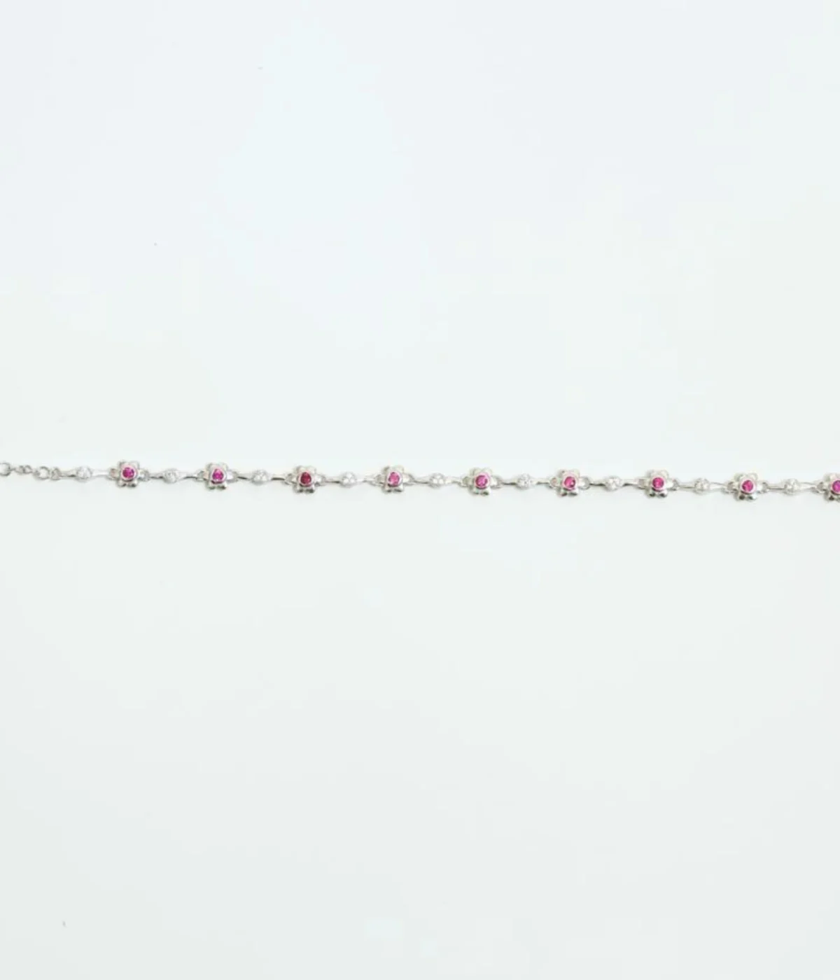 NeerSterling Silver Dainty Pink Gemstone Line Bracelet. Features a continuous line of tiny flower motifs with central pink stones (CZ/Ruby color). Minimalist 925 silver jewelry.