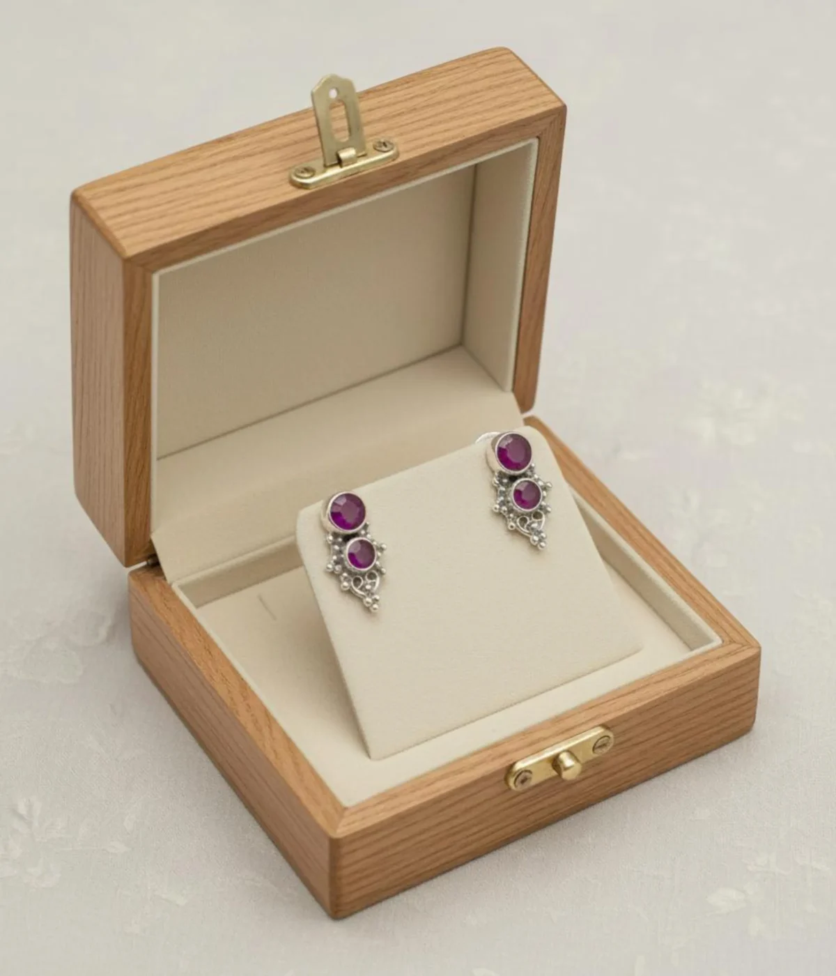 Pair of Oxidized Silver Stud Earrings. Ethnic ruby stone cluster design with intricate detailing, displayed in an open light wood jewelry gift box.