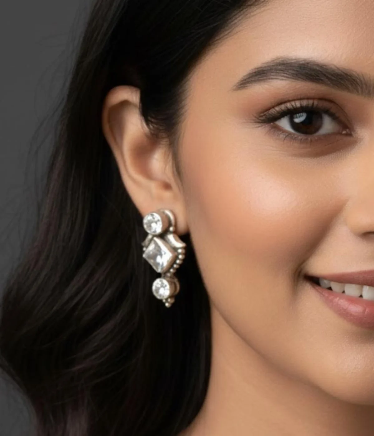 Pair of Oxidized Stud Drop Earrings. Vintage style silver tone dangles with a central Square CZ Stone, displayed in a velvet-lined wooden jewelry box.