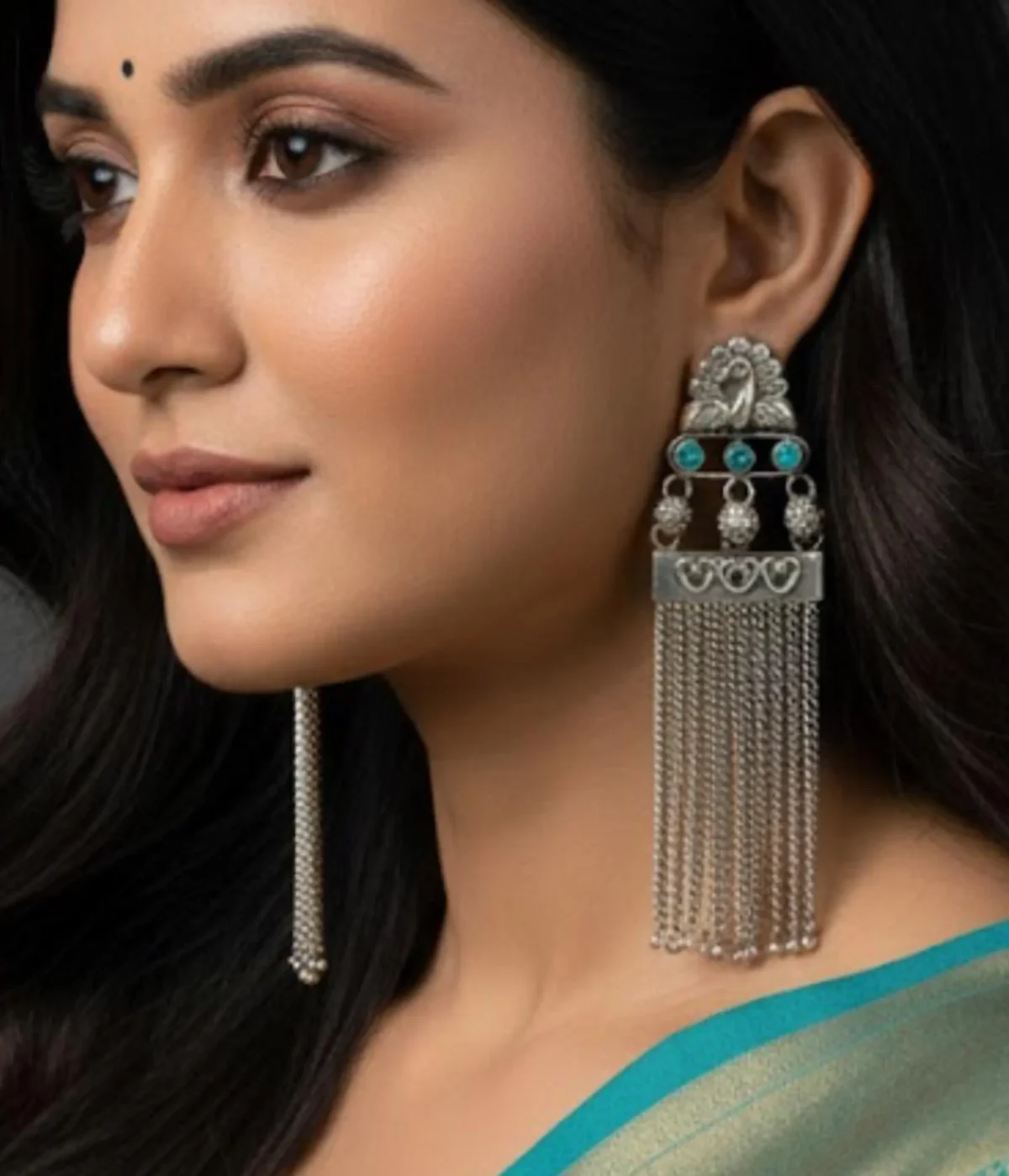 Long Oxidized Silver Tassel Chandelier Earrings (16.9 gm) being worn by a woman. The Indian Ethnic design features a Peacock Motif, Blue Stone accents, and cascading chain dangles.