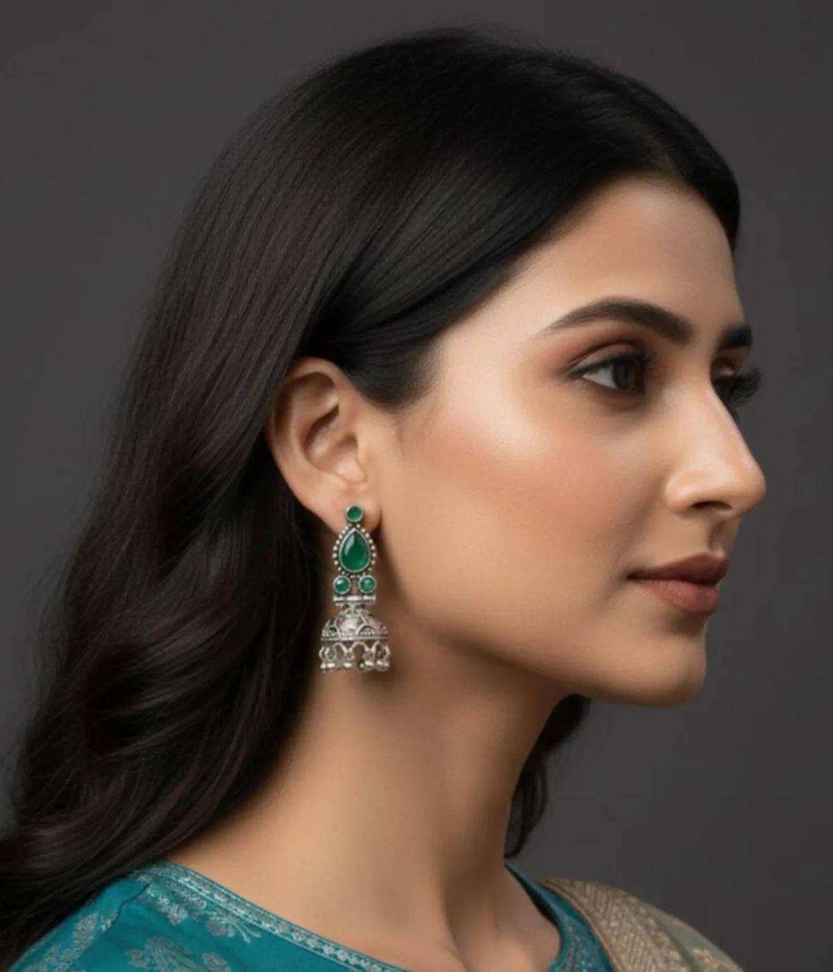 Traditional Oxidized Silver Jhumka Earrings (13.7 gm) being worn. Features a Green Teardrop Stone stud, bell-shaped base, and Pearl Drop clusters. Indian Ethnic Festive Jewelry.