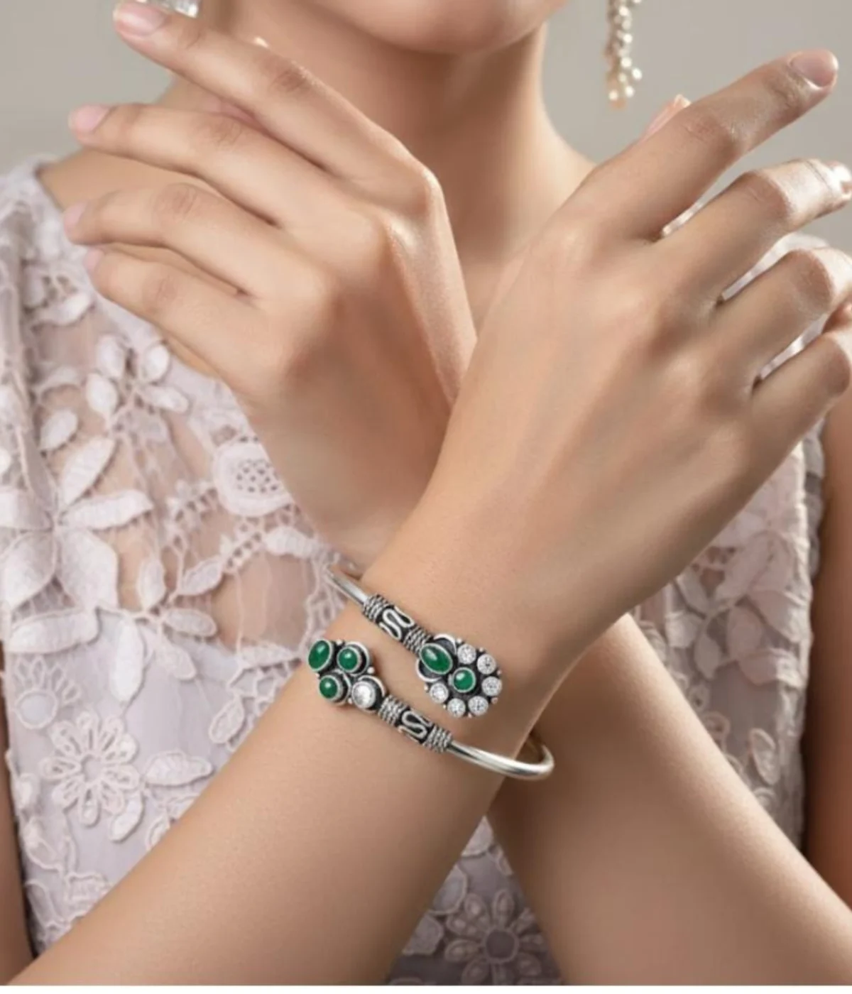 Detailed 17.1 gm oxidized silver floral kada featuring vibrant emerald green stones and clear zirconia accents on a white background.