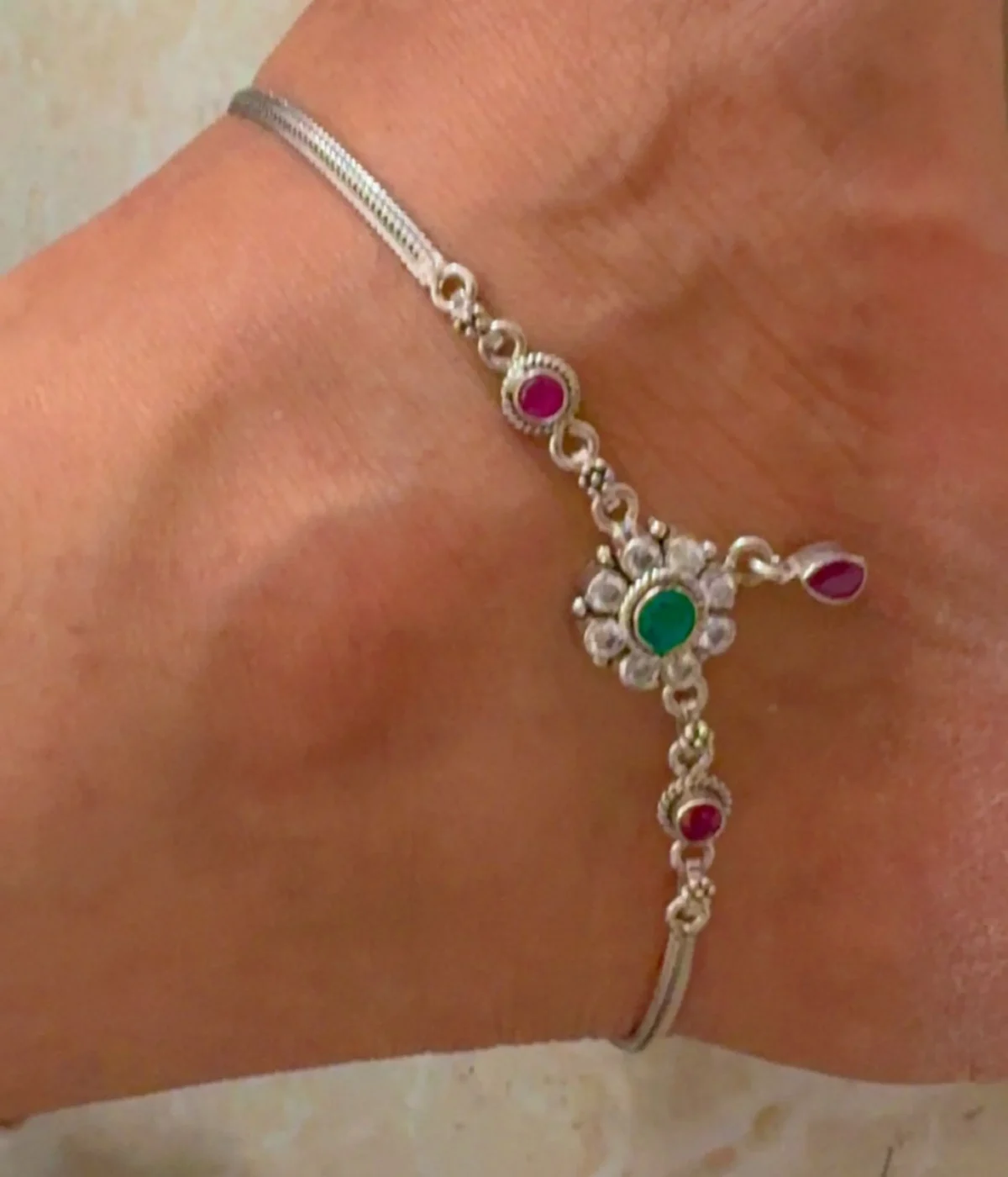 Traditional Ruby & Green Stone Anklet (Payal, 35 gm). Oxidized Silver Floral Chain with dual-tone CZ stone links, displayed on a red velvet stand inside a dark wood gift box.