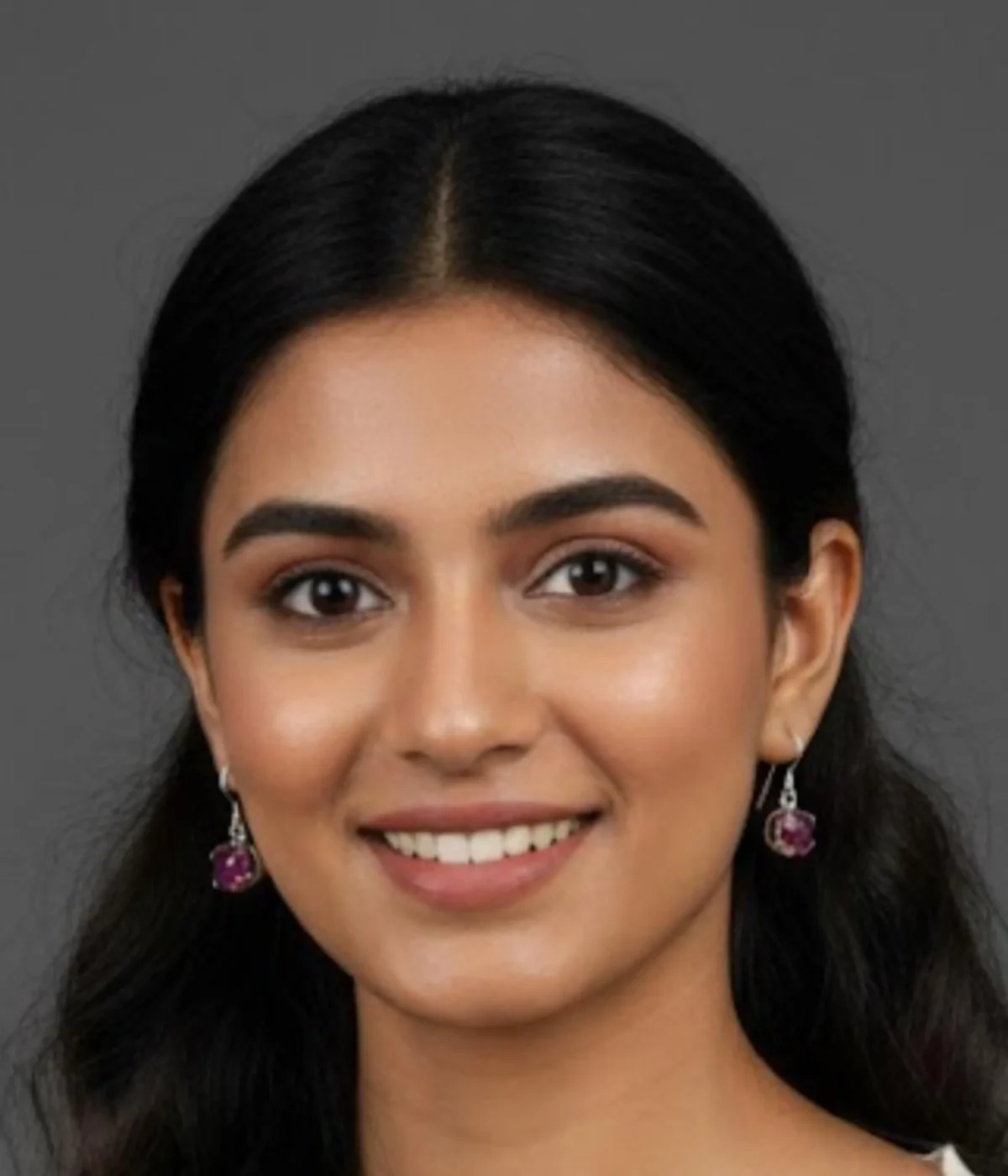 Pair of Minimalist Round Ruby Stone Hook Earrings (1 gm). Features a pink/ruby solitaire stone in a silver six-prong setting, displayed on a red velvet stand inside a dark wood gift box.