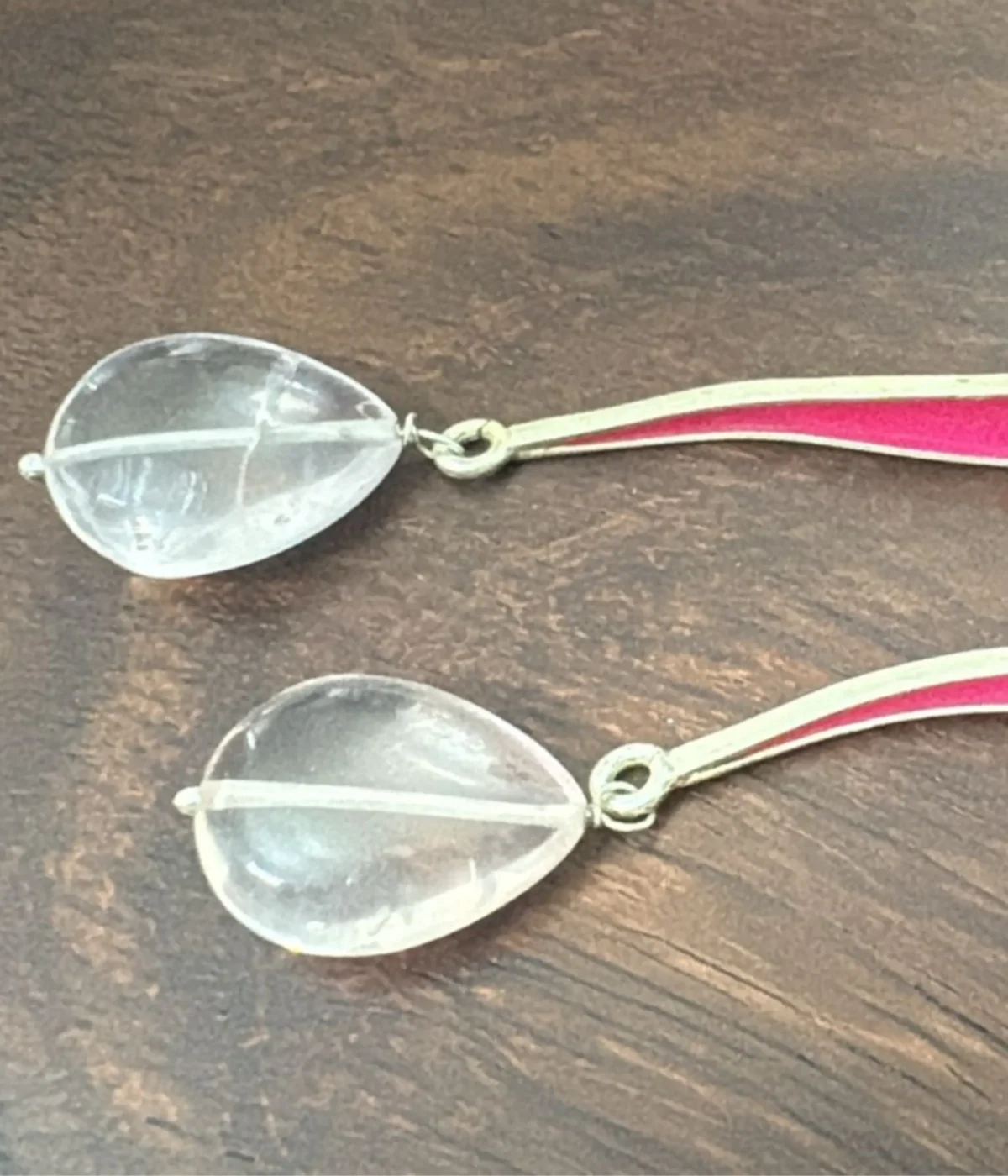 Long Teardrop Quartz Dangle Earrings (6.6 gm) with clear stone drops and a curved pink/red enamel accent bar. The modern, lightweight earrings are displayed inside a wooden jewelry box lined with blue velvet.