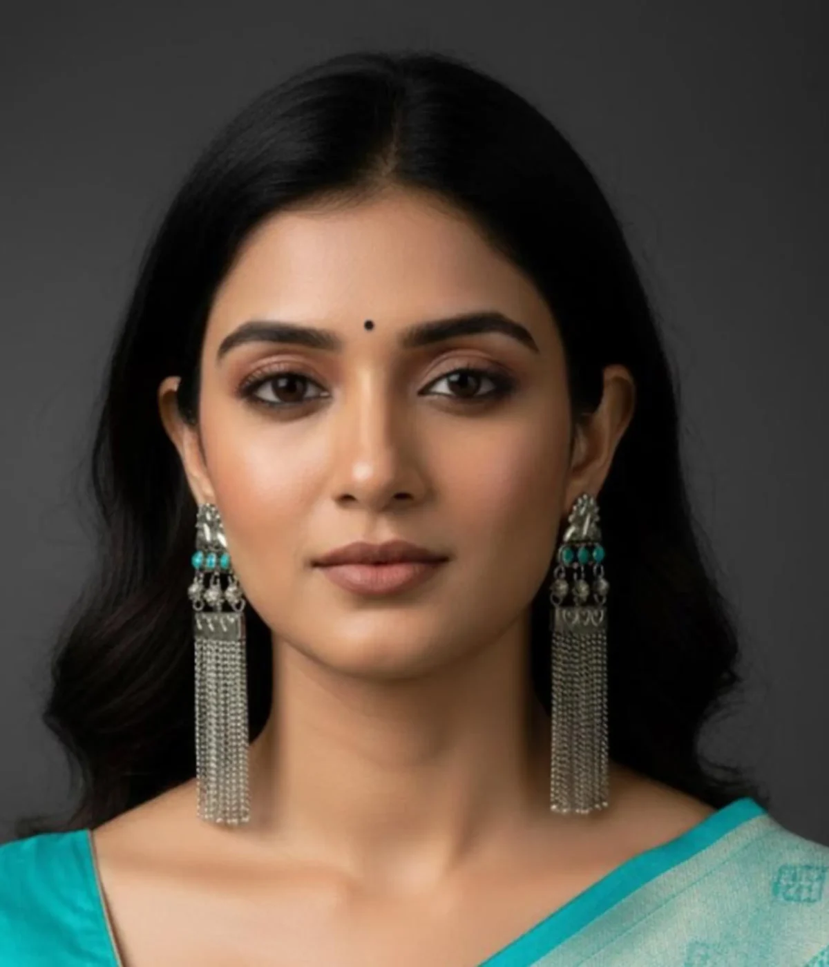 Long Oxidized Silver Tassel Chandelier Earrings (16.9 gm) being worn by a woman. The Indian Ethnic design features a Peacock Motif, Blue Stone accents, and cascading chain dangles.
