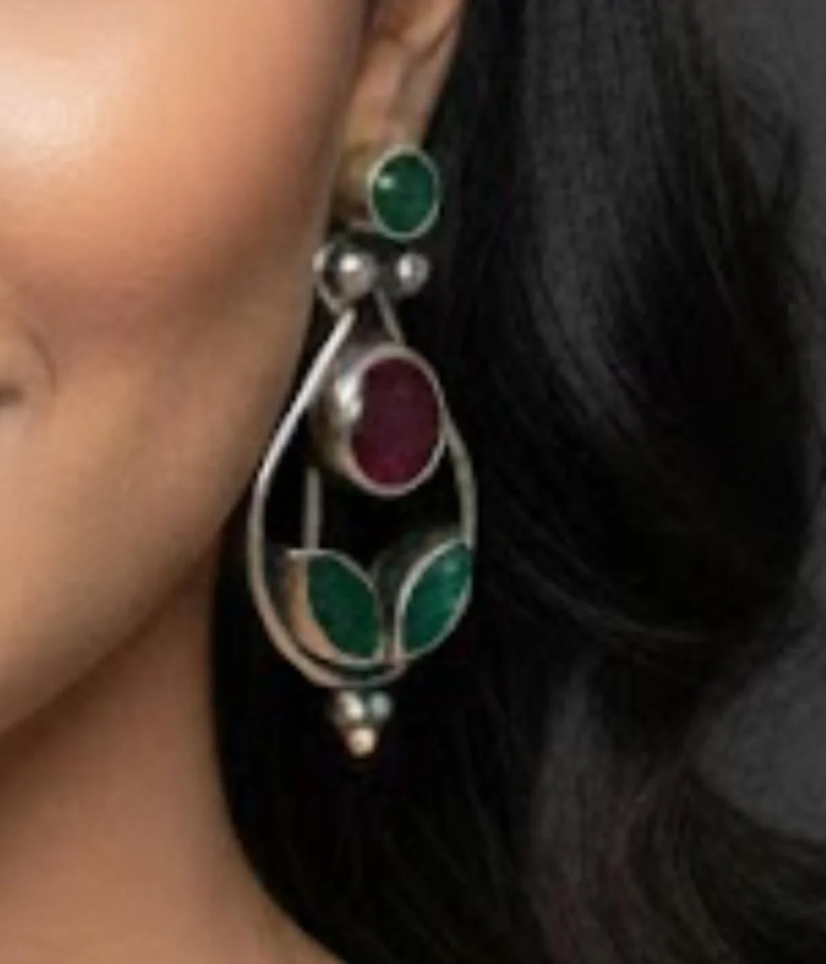 Pair of Oxidized Teardrop Dangle Earrings (5.9 gm). Ethnic style jewelry featuring Ruby and Green CZ Stones, displayed on a red velvet stand inside a dark wood gift box.