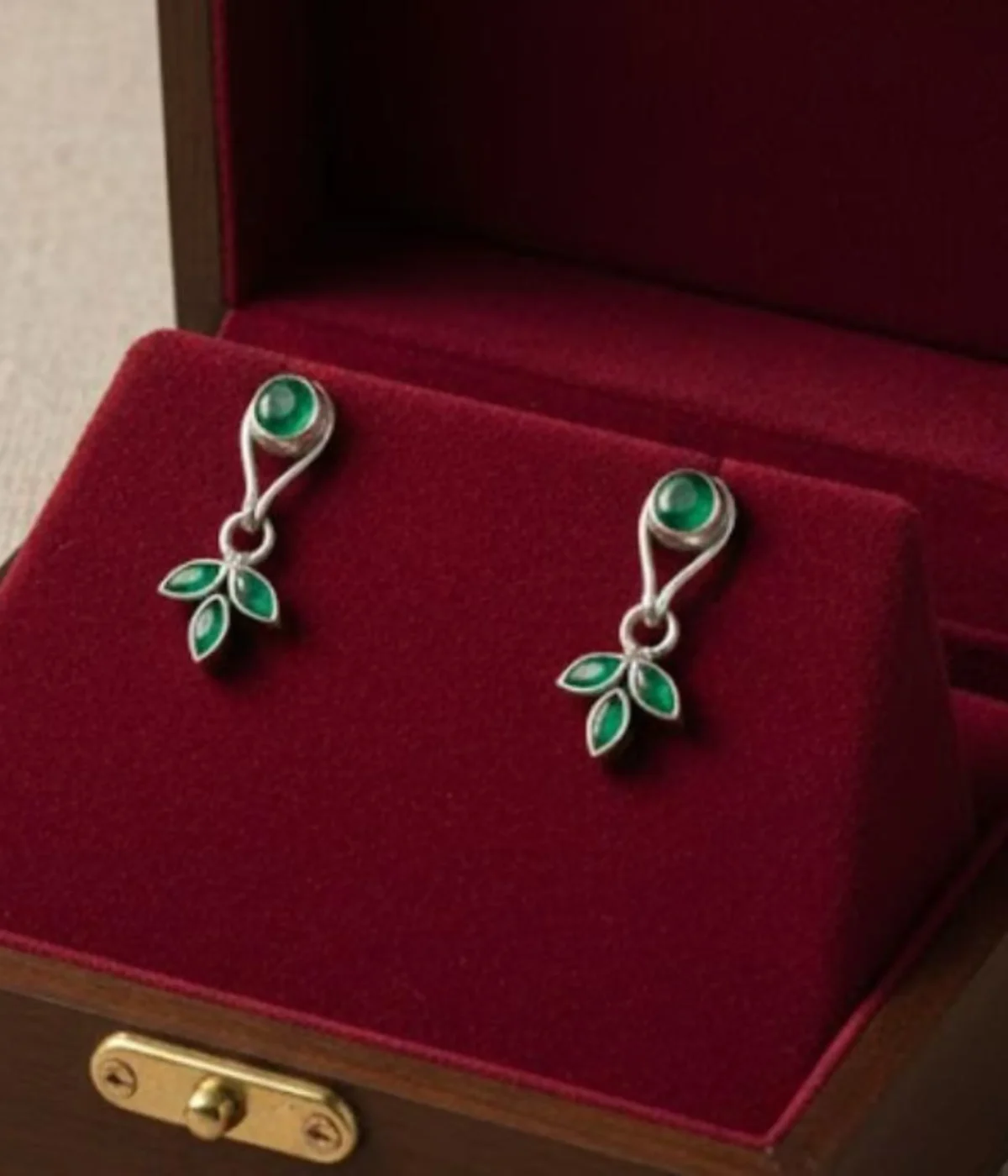 Pair of Minimalist Silver Leaf Drop Earrings (4.15 gm). Nature-inspired design featuring a Green Emerald Stone stud and a three-leaf dangle.