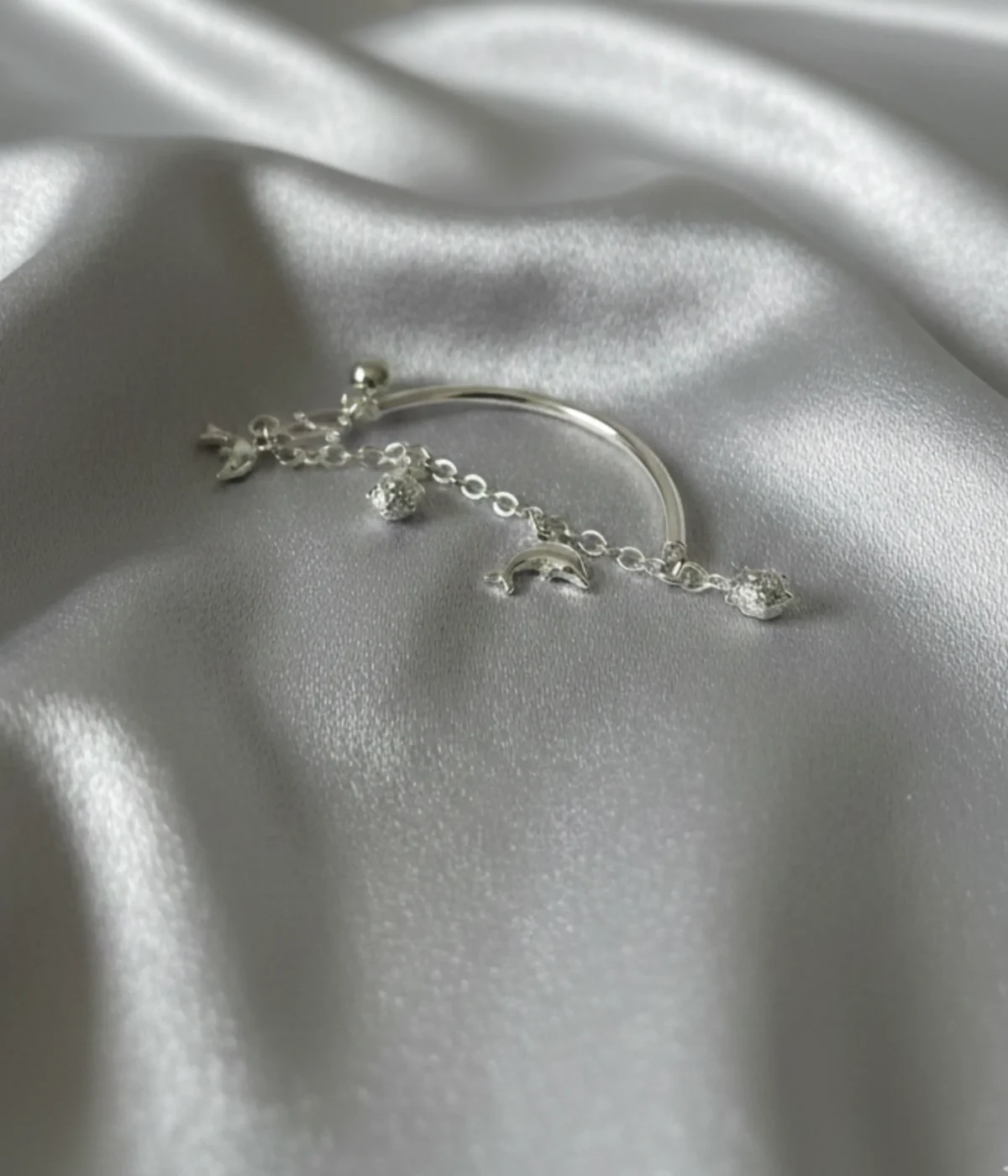 Handcrafted 925 sterling silver kids bracelet with dolphin charms on a child’s wrist, 6g lightweight adjustable bangle.