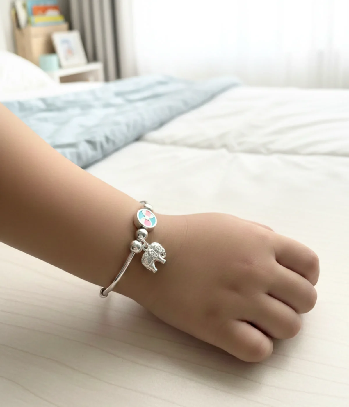 Handcrafted 925 sterling silver kids elephant bangle pair with pink and turquoise enamel charms shown on a child's wrist, 22.8g adjustable baby jewelry.